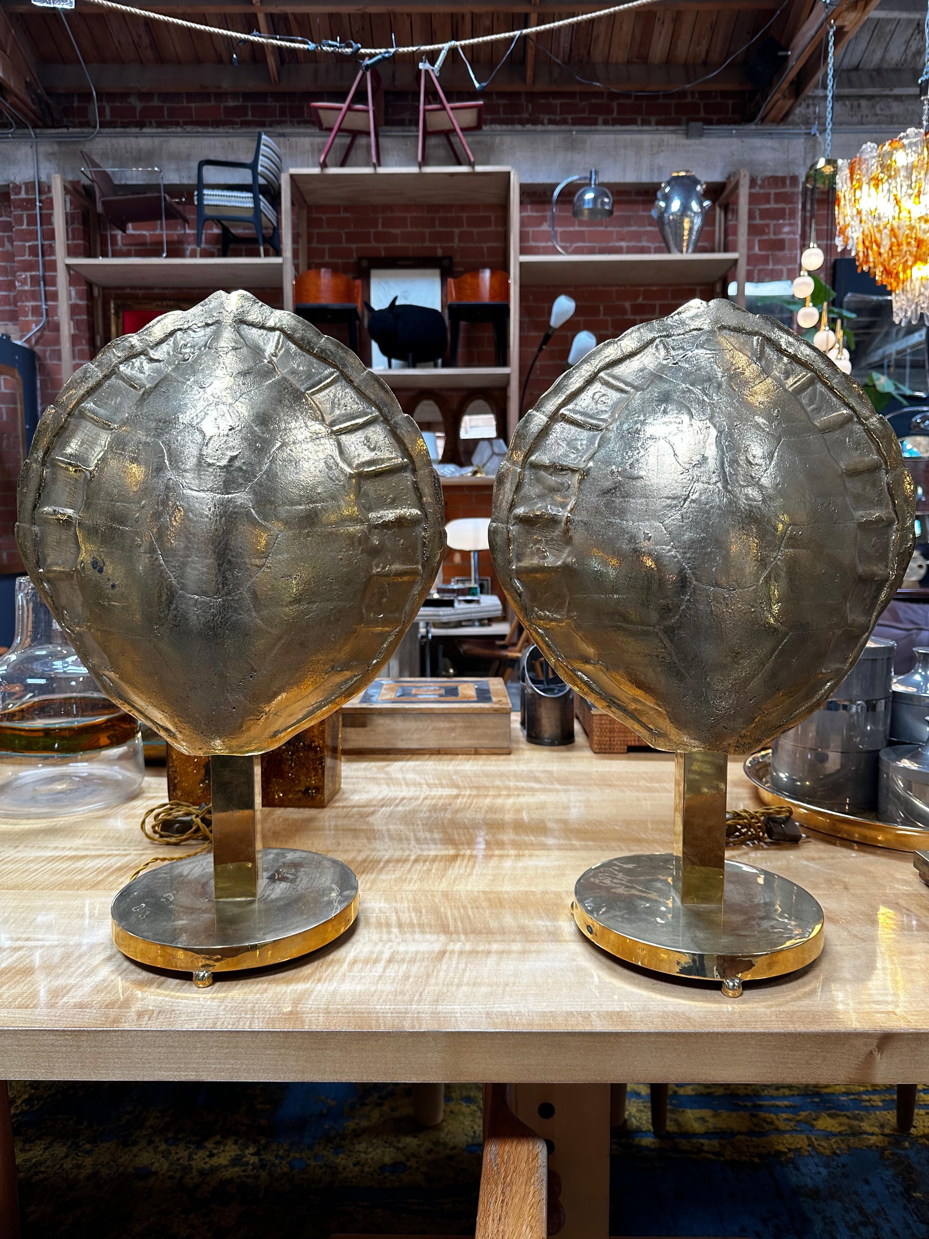 Cette paire de lampes de table à coquille entièrement en laiton, fabriquée en Italie dans les années 1960, est un bel exemple du design d'éclairage moderne du milieu du siècle. Les lampes sont dotées d'une coque entièrement en laiton, qui a été