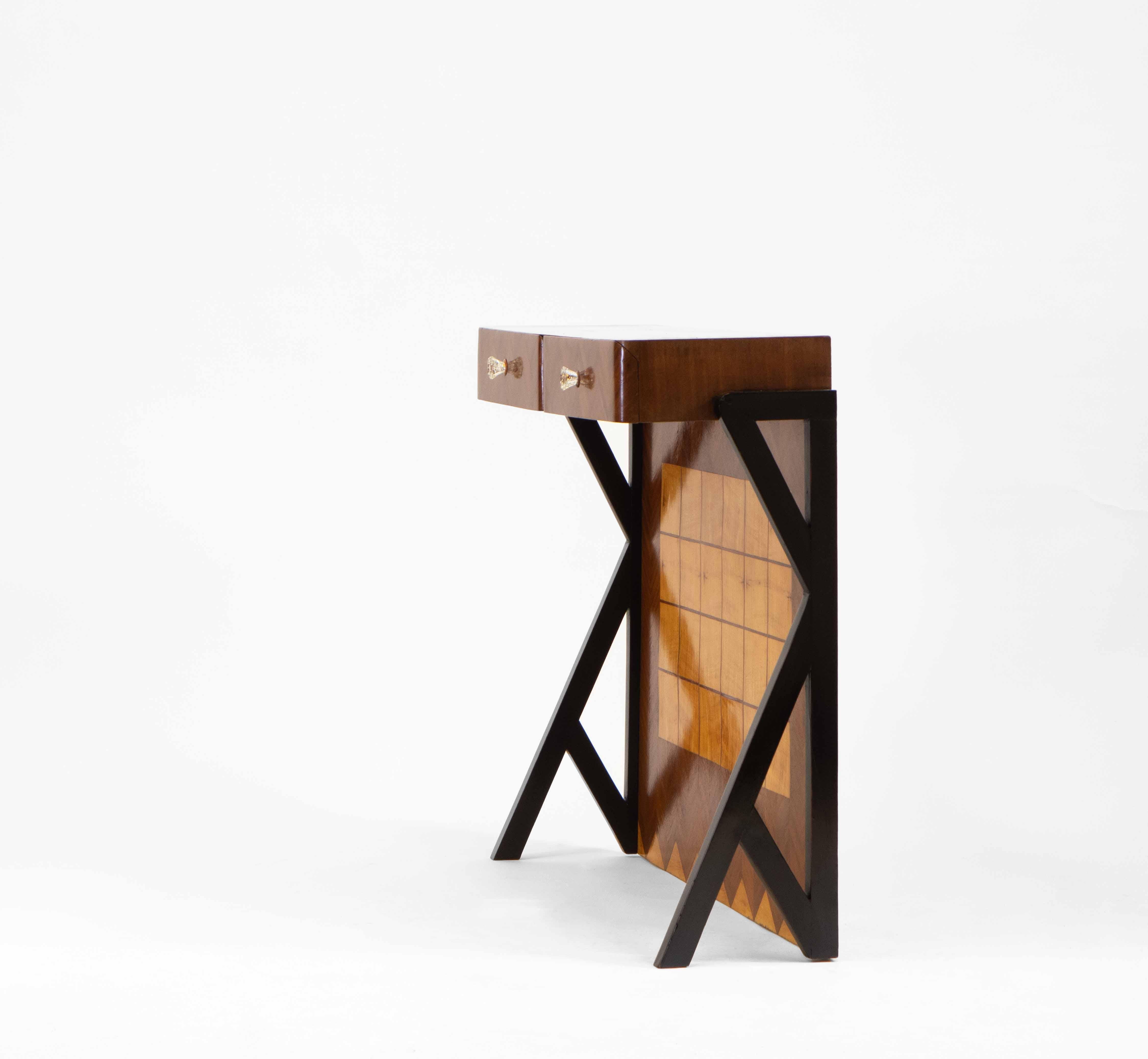 A mid-century Italian Futurist style two drawer console table, circa 1950.

With geometric parquetry decoration in maple and sapele veneers, the table stands on striking ebonised legs. The drawers have the original cut glass handles, these are of a