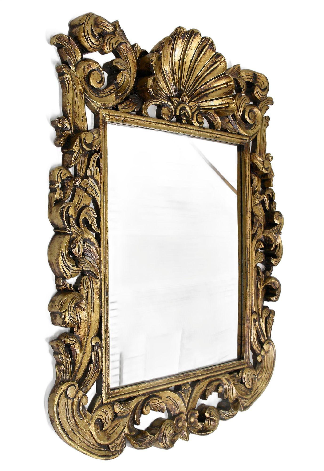 One of a kind, monumental gilt Florentine mirror from the early mid century period around 1940/50 in Italy. This extraordinary 20th century Italian wall mirror impresses with its massive artfully, open worked frame showing an absolutely gorgeous