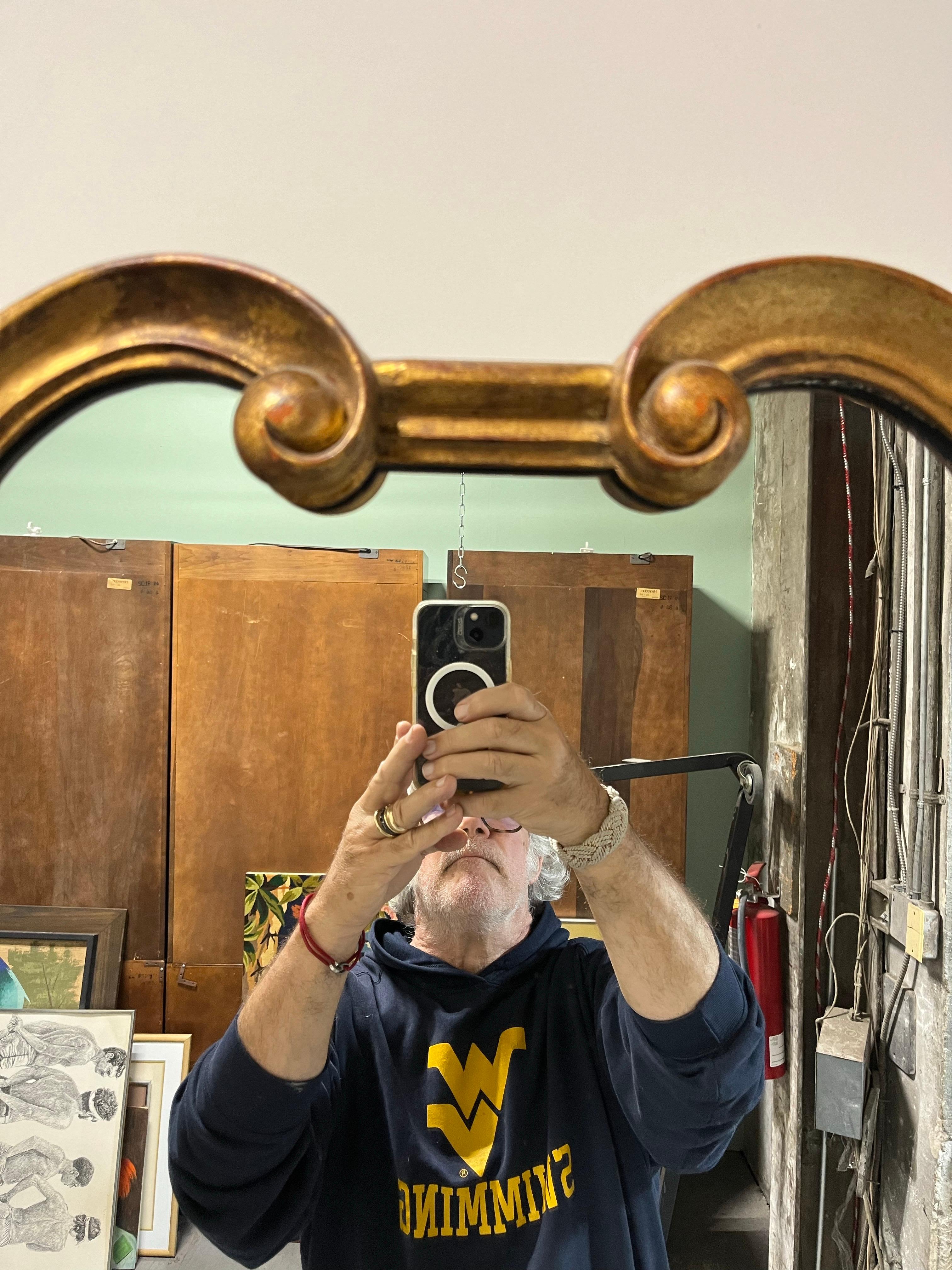 Beautiful classic. Mid Century Hollywood Regency carved wood and gilt mirror. Uniquely large. Italian made by Palladio. Circa 1960's.