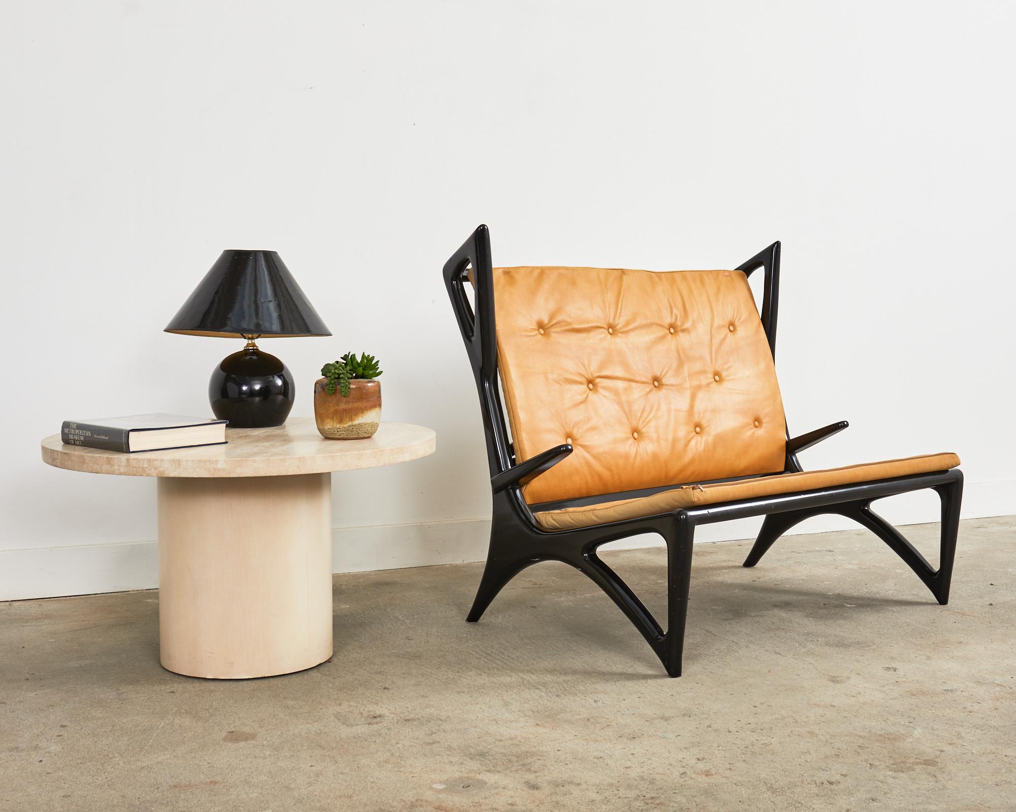 Dramatic Mid-Century Modern Italian sculptured settee or bench with wings. The settee features a black lacquer ebonized finish on the stylish frame with radically designed angular wings and legs. The gracefully curved frame is topped with button