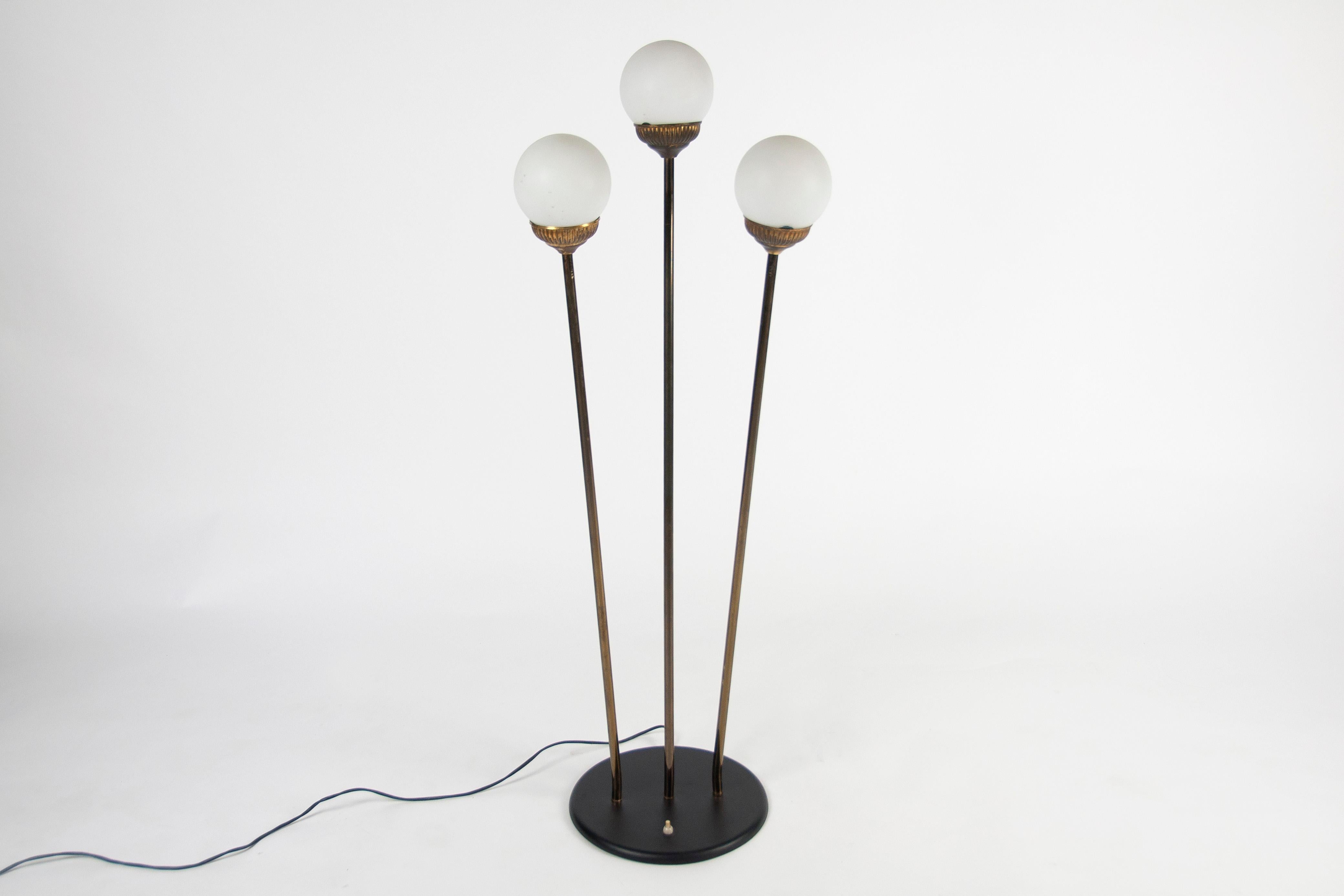Beautiful Italian floor lamp from the 50s, original model attributed to stilnovo. The arms are adjustable in different directions and the globes are made of opaline glass. The three lamps can be switched on or off independently for more or less