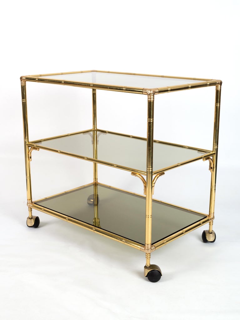 Mid-century Italian gold brass bamboo three tier bar cart C.1960
Three tier etagere.
Smoked glass shelves.
Excellent condition commensurate with age, with minimal signs of wear.