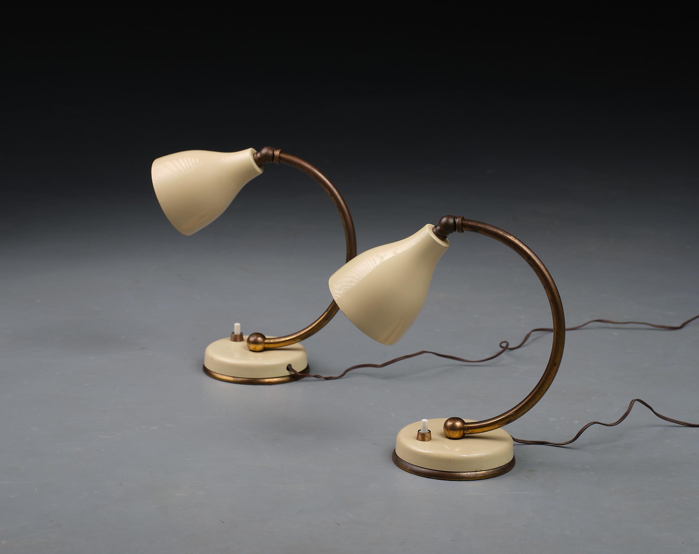 Presenting a pair of gracefully designed Italian table lamps from the 1950s, these pieces blend the elegance of aged brass with the softness of cream-colored lacquered metal. Each lamp showcases a stunning patina that highlights the beauty of its