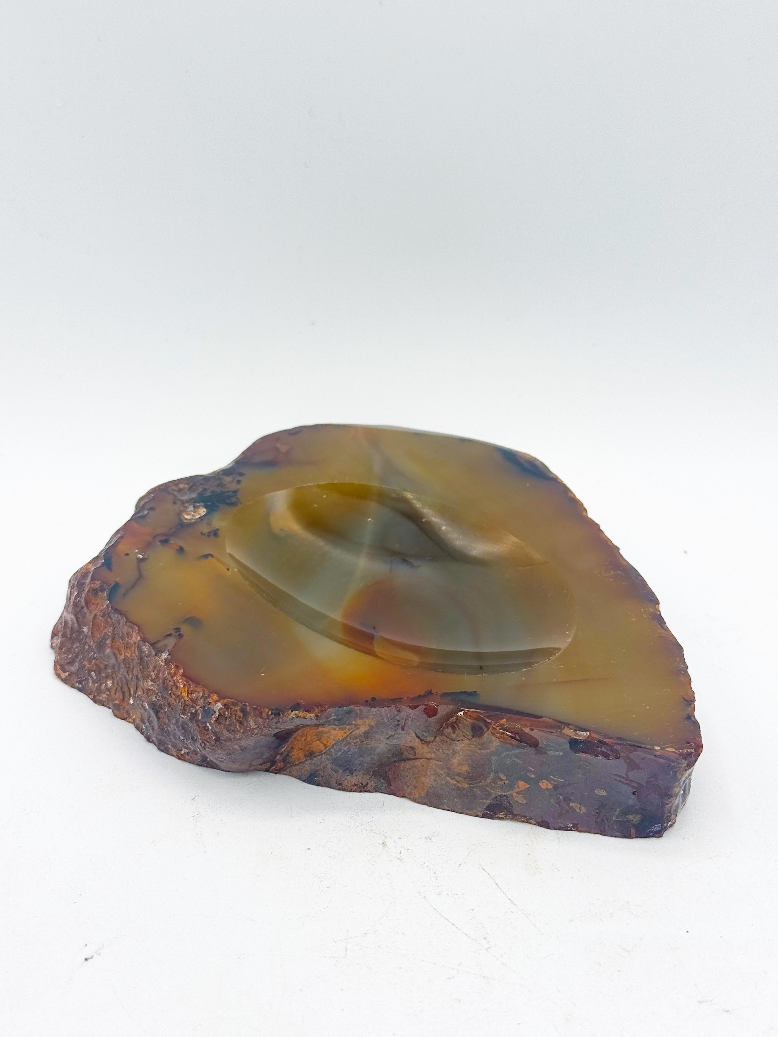 Cendrier ou vide-poche italien du milieu du siècle, fabriqué à la main à partir d'une seule pièce d'agate naturelle et poli pour obtenir une finition brillante et vitreuse. Fabriquée en Italie dans les années 1950, cette pièce sculpturale présente
