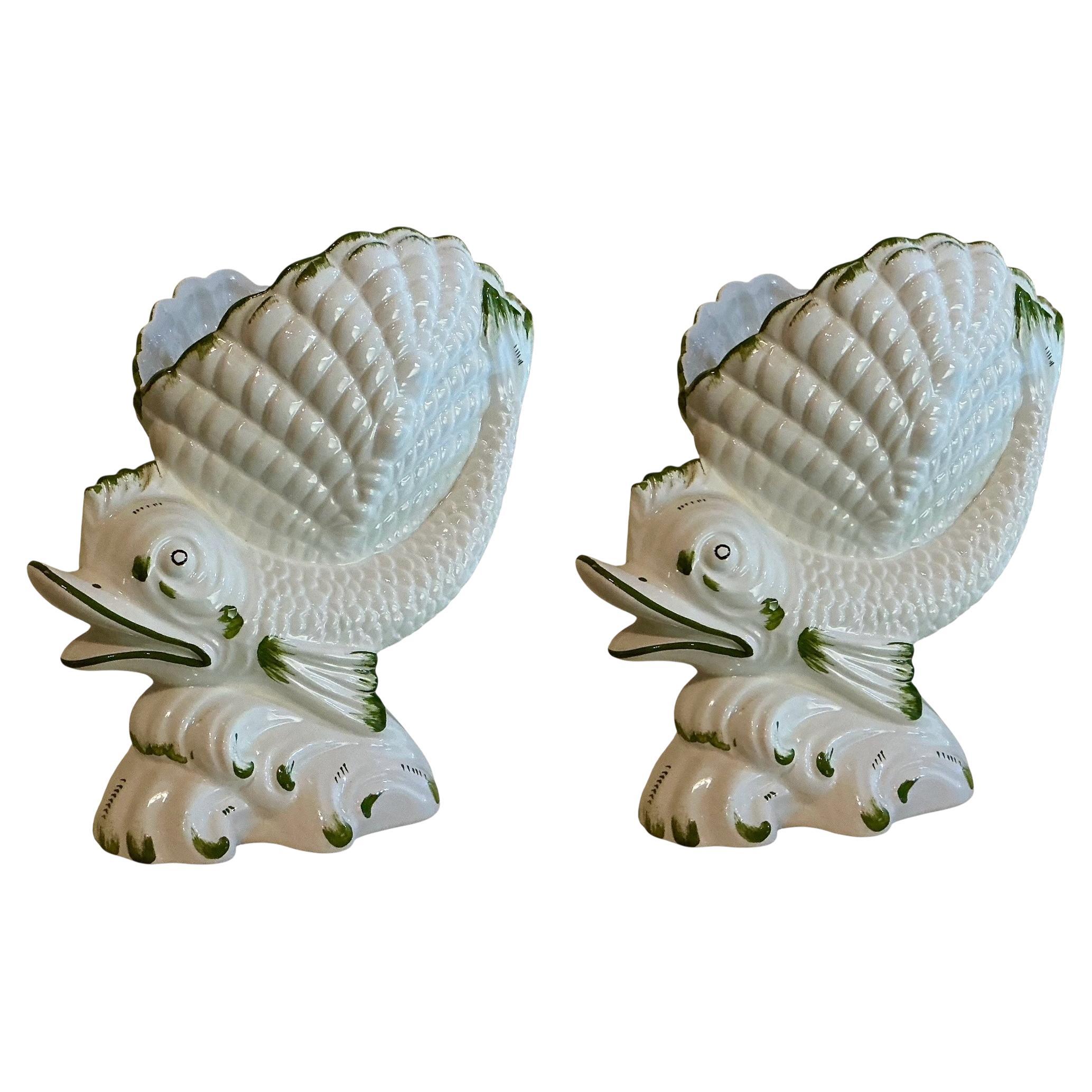 This is a pair of Hollywood Regency Era Italian signed ceramic Cachepot or figurines. They are white and green and signed on the underside. They depict a fish riding a wave with a shell on its back. Both are in very good condition. 