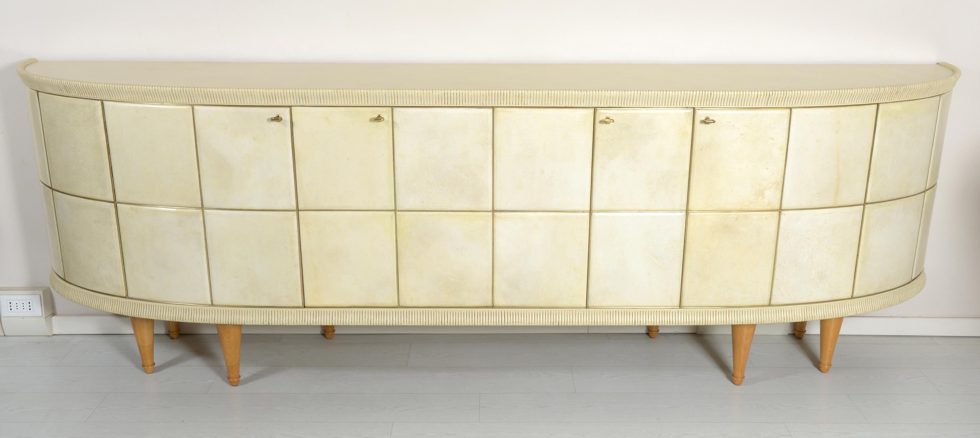 Sideboard with a beautiful rounded semi-moon shape, front with maple relief panels completely covered in parchment edged with brass rods, two central folding doors that open and slide into a brass track. The side doors open normally and have on the