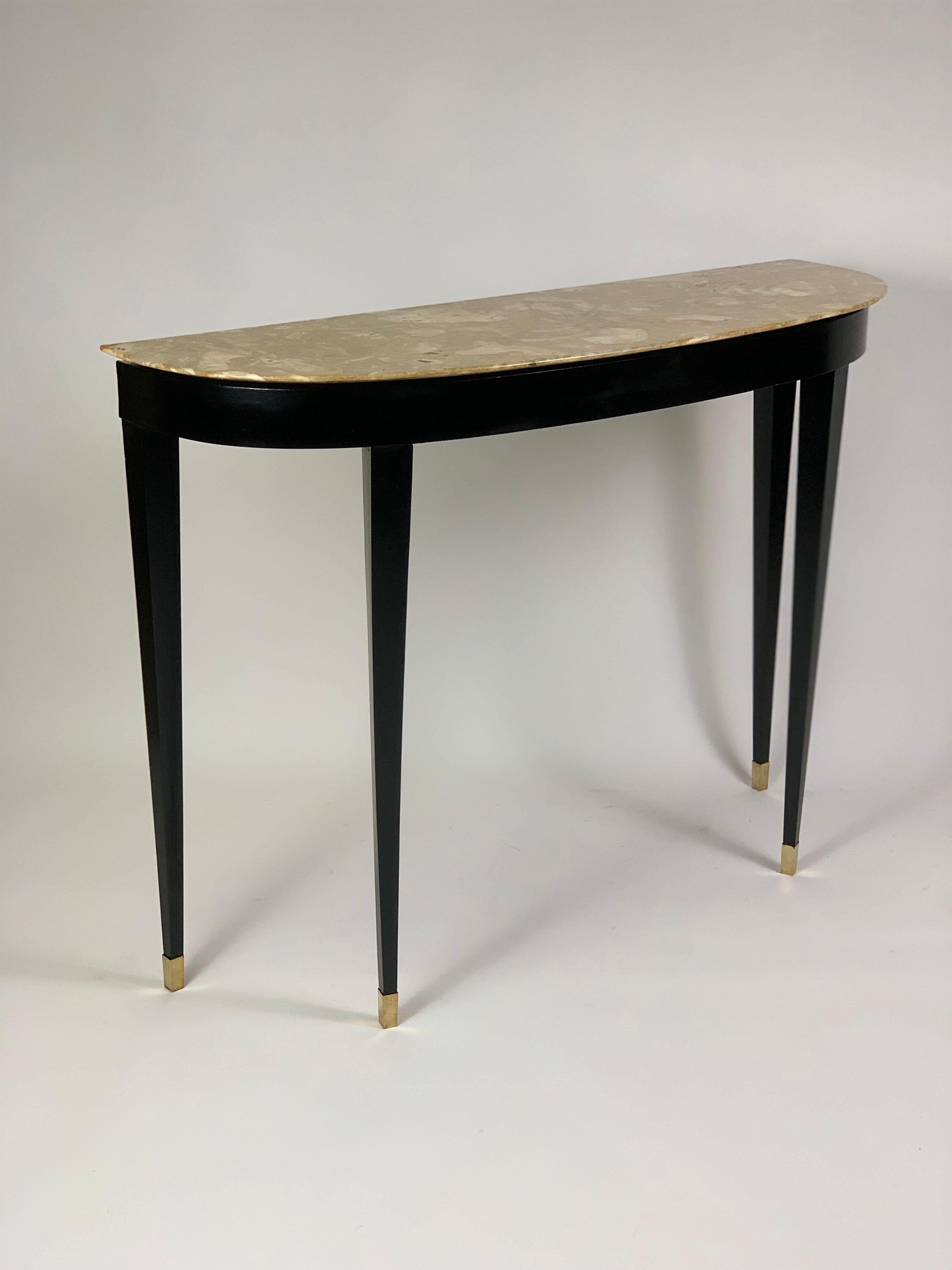 Mid Century Italian console table with four pyramidal legs supporting a semi-moon shaped top.
The console top is in beautiful variegated marble breccia with an inverted owl's beak edge.
The structure is black lacquered and the legs end at the