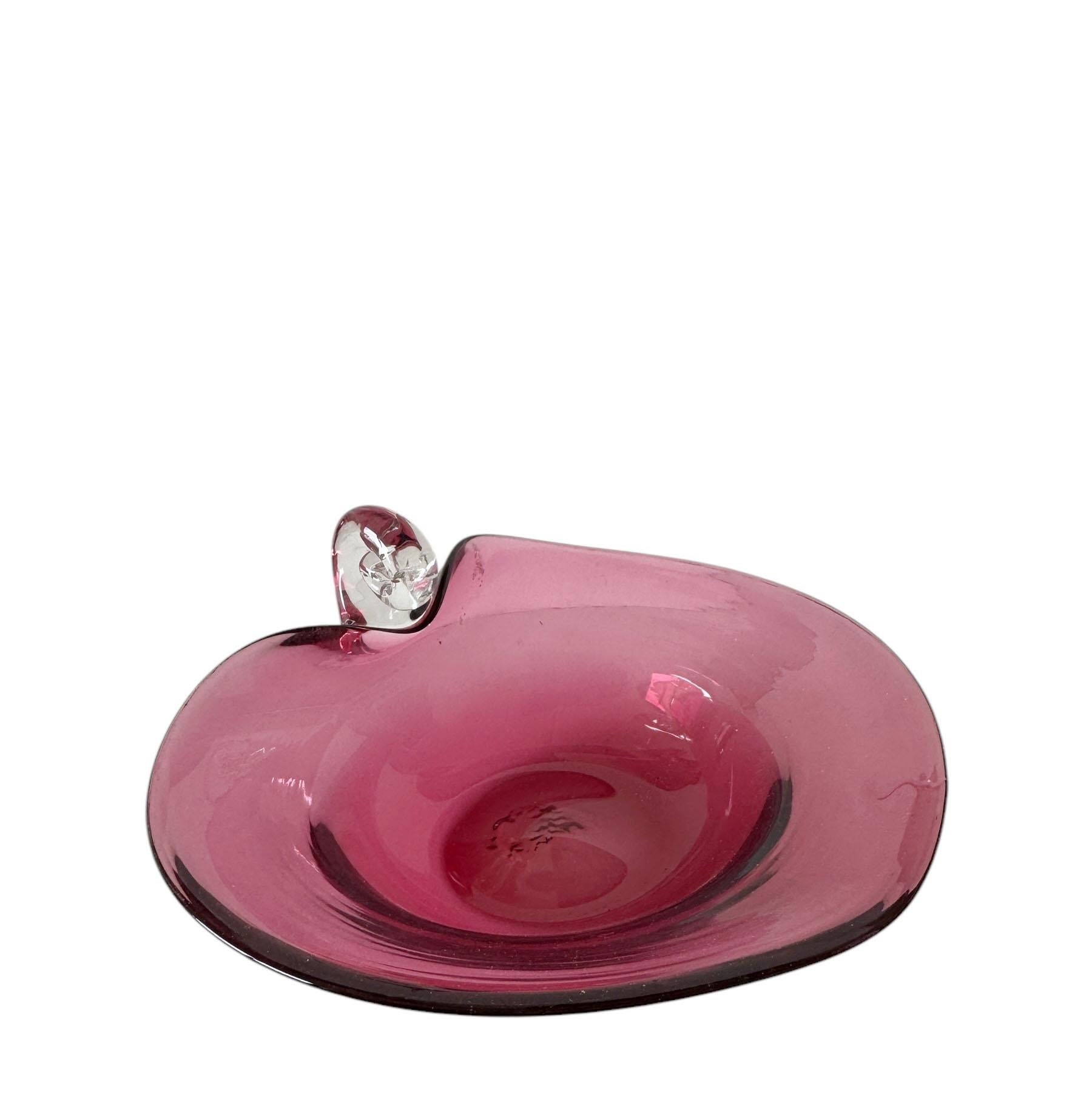 Un superbe plat en verre d'art italien. En forme de cœur et d'un rose riche et profond. Il est doté d'une poignée en verre transparent magnifiquement travaillée, alliant fonctionnalité et flair artistique. Parfaite comme accent décoratif,