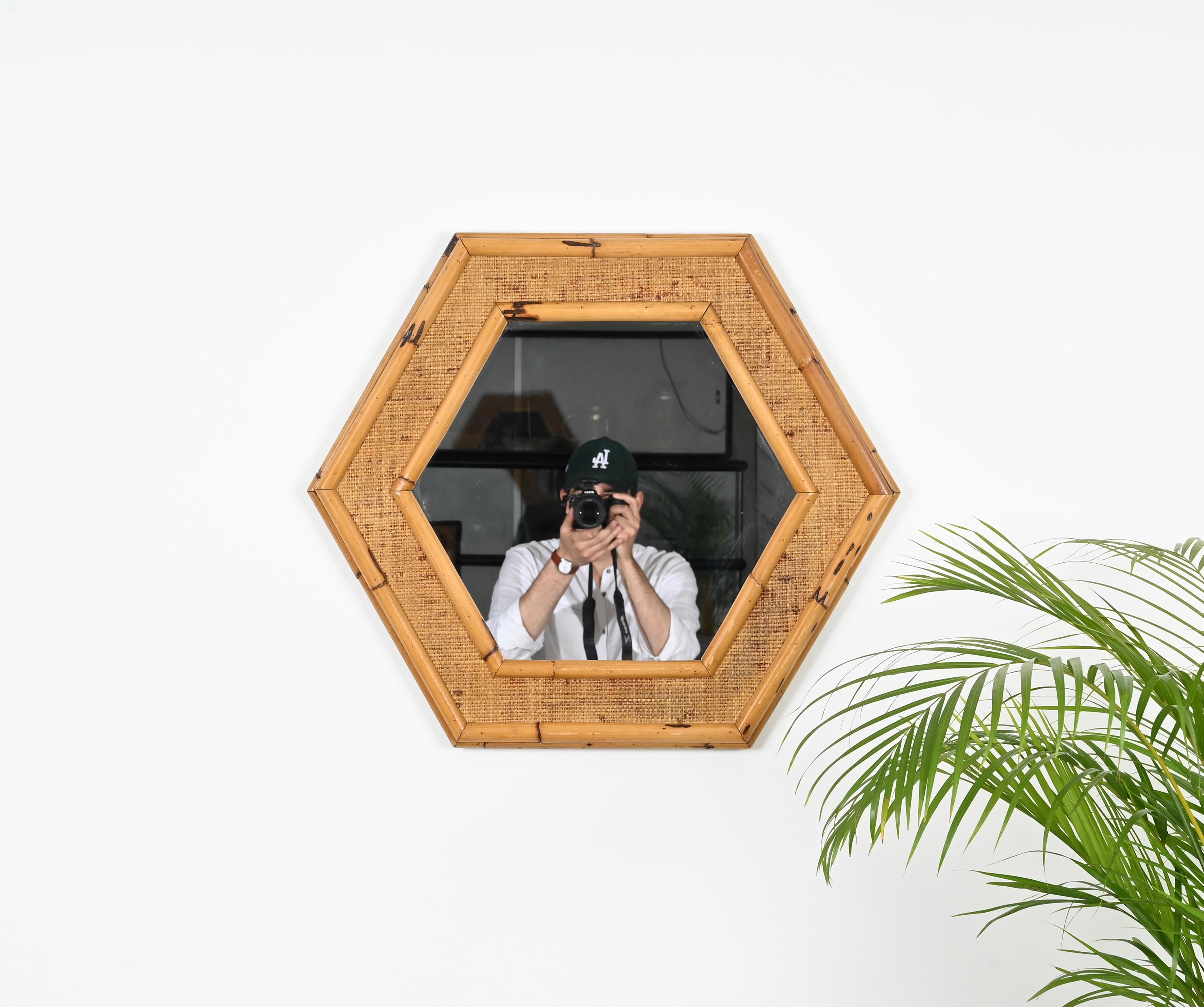 Stunning Mid-Century French Riviera style hexagonal mirror in bamboo and woven rattan. This unique and charming mirror was made in Italy during the 1970s. 

This lovely organic mirror has an hexagonal double frame made in bamboo which is enriched