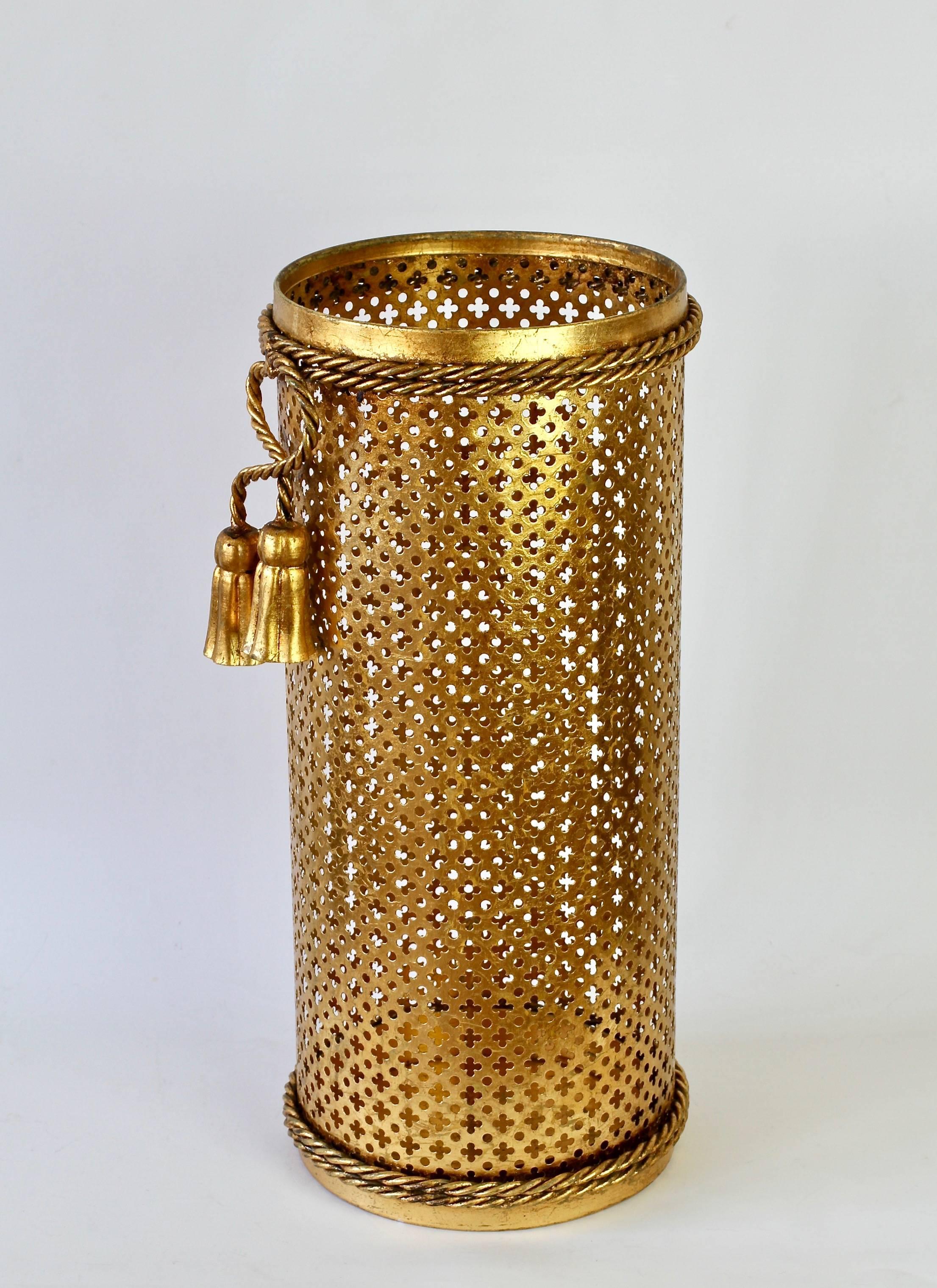 Stunning midcentury gold/gilt/gilded Hollywood Regency style umbrella stand or holder made in France or Italy, circa 1950. The perforated lattice patterned metalwork with bent rope and tassel details finish the piece perfectly. Quite rare to find