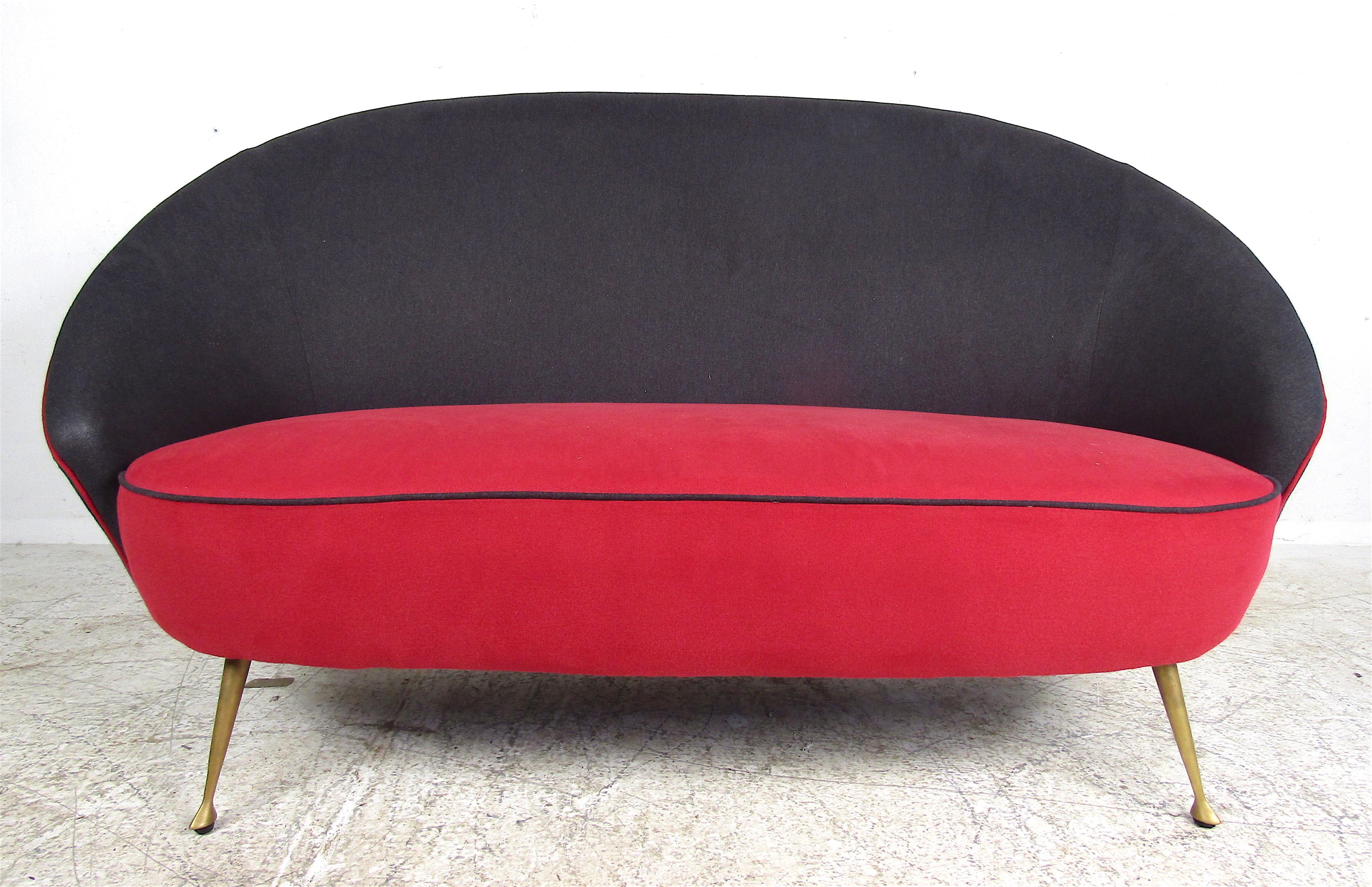 This beautiful vintage 1960s loveseat boasts splayed brass legs with sculpted feet. A sleek and sturdy Italian design with an ellipse-shaped backrest and overstuffed seating. A wild red and black velvet fabric that is sure to make an impression in