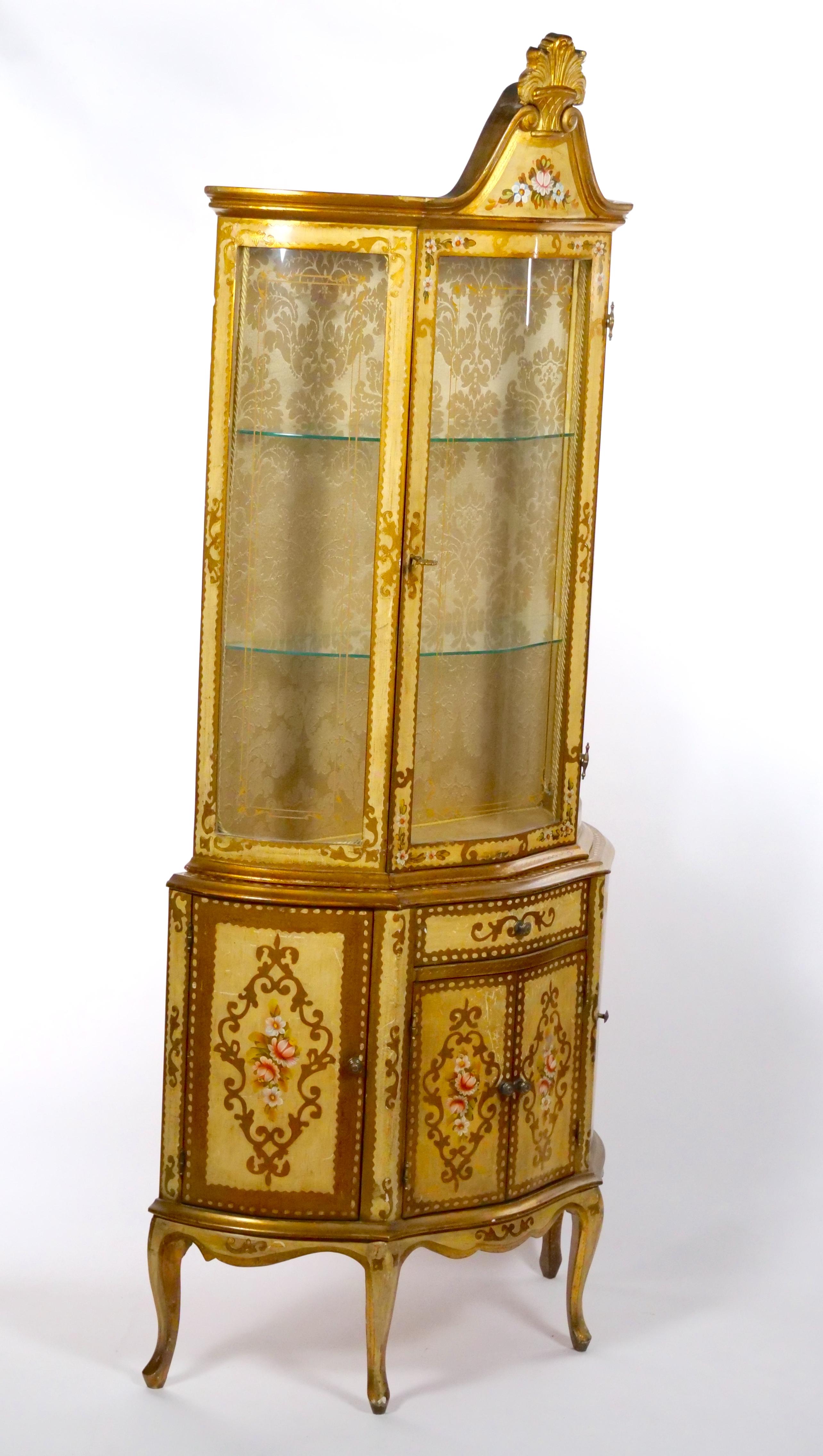 Beautiful and elegant mid 20th century Tuscan showcase / vitrine cabinet , in a lacquered, gilded and hand painted wood with very pleasant floral decorations. Two part body display cabinet equipped with four doors and a drawer in the lower section.
