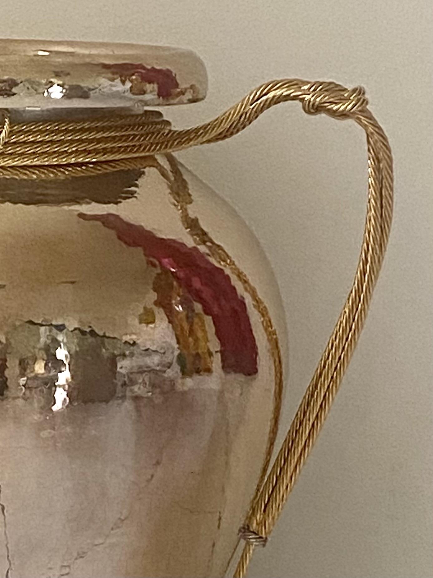Un joli vase martelé à la main d'Edigio Broggi Milano avec des détails de corde dorée comme poignées et une garniture de corde nouée sur la lèvre. Le logo et Made in Italy sont estampés sur le fond du vase. 
 