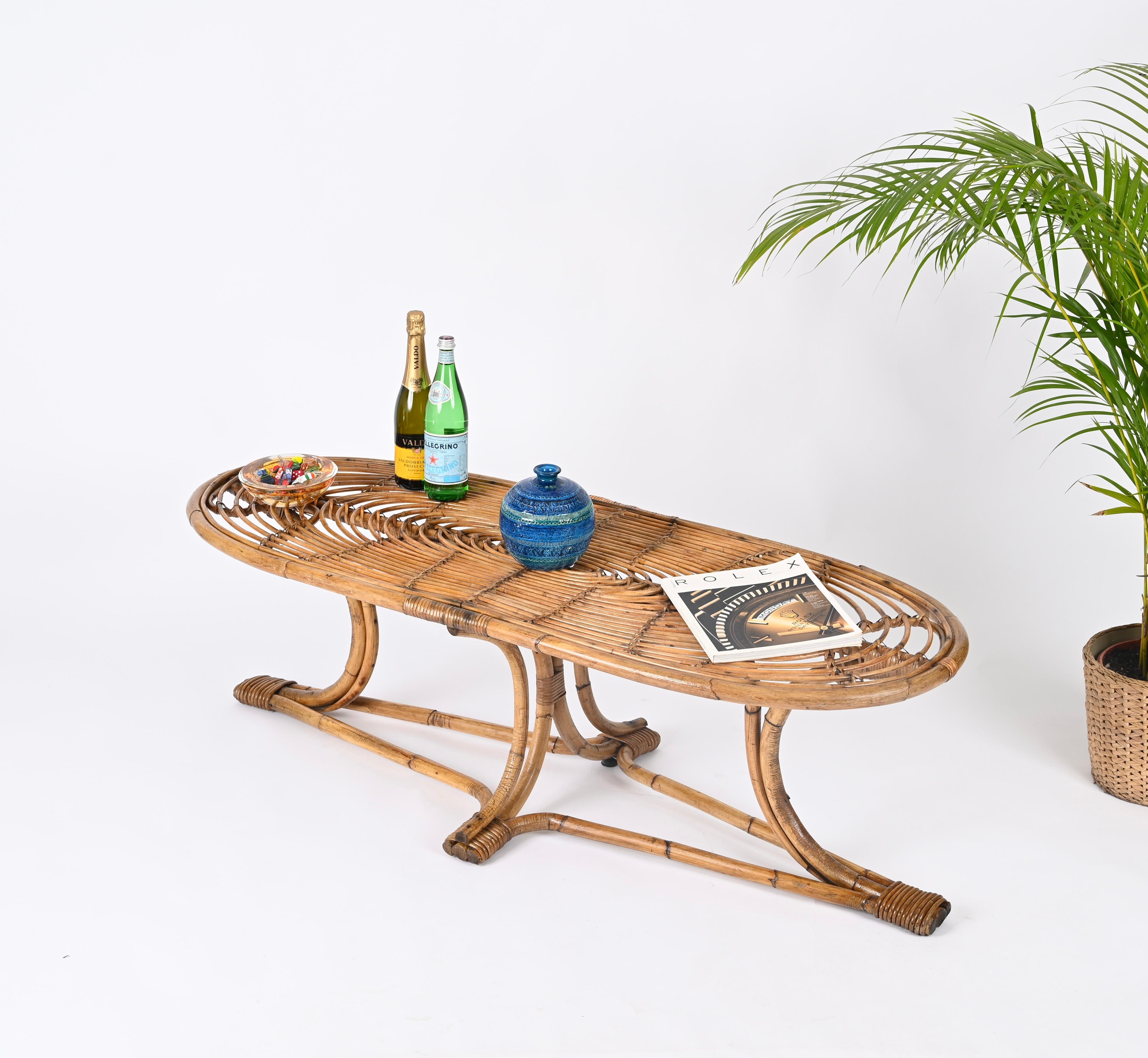 Merveilleuse grande table basse entièrement réalisée en bambou courbé, rotin et osier tressé à la main. Cette pièce fantastique et unique a été réalisée en Italie dans les années 1970. 

La table se caractérise par une base étonnante composée de