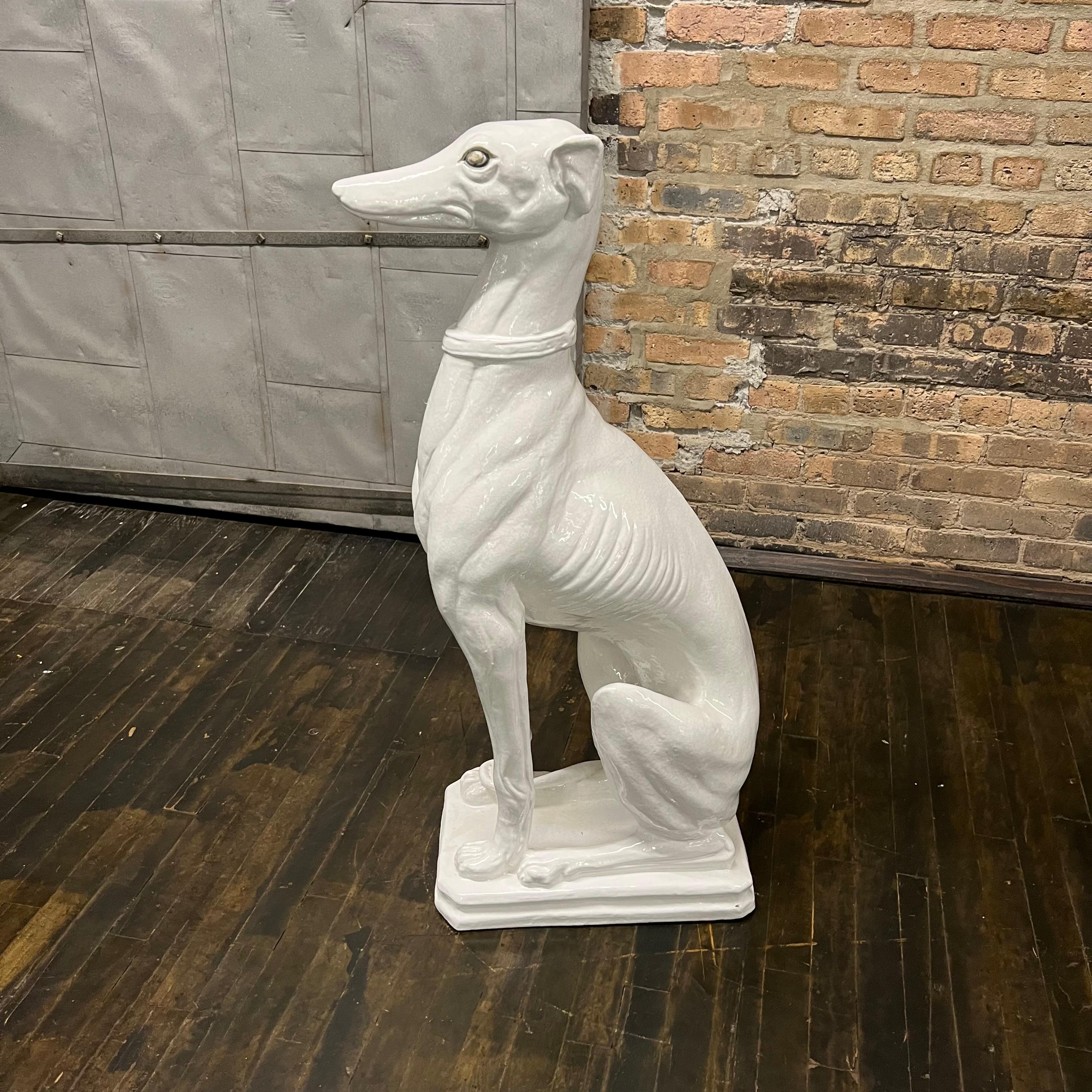 This vintage Italian midcentury white porcelain sculpture, artfully depicts an obedient greyhound dog. The greyhound, known for its slender, streamlined body and swift agility, is portrayed sitting and displaying a calm and submissive demeanor (his
