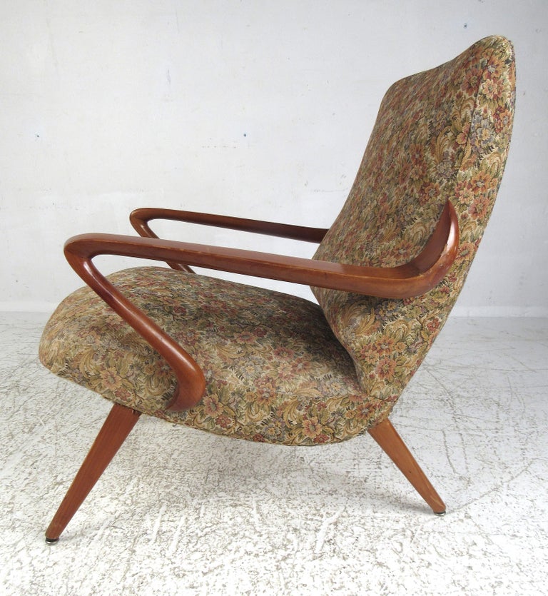 This incredible lounge chair features a truly unique sculpted wood frame with an upholstered seat with tapered legs. The vintage floral fabric adds to the midcentury Italian charm. Please confirm item location (NY or NJ).