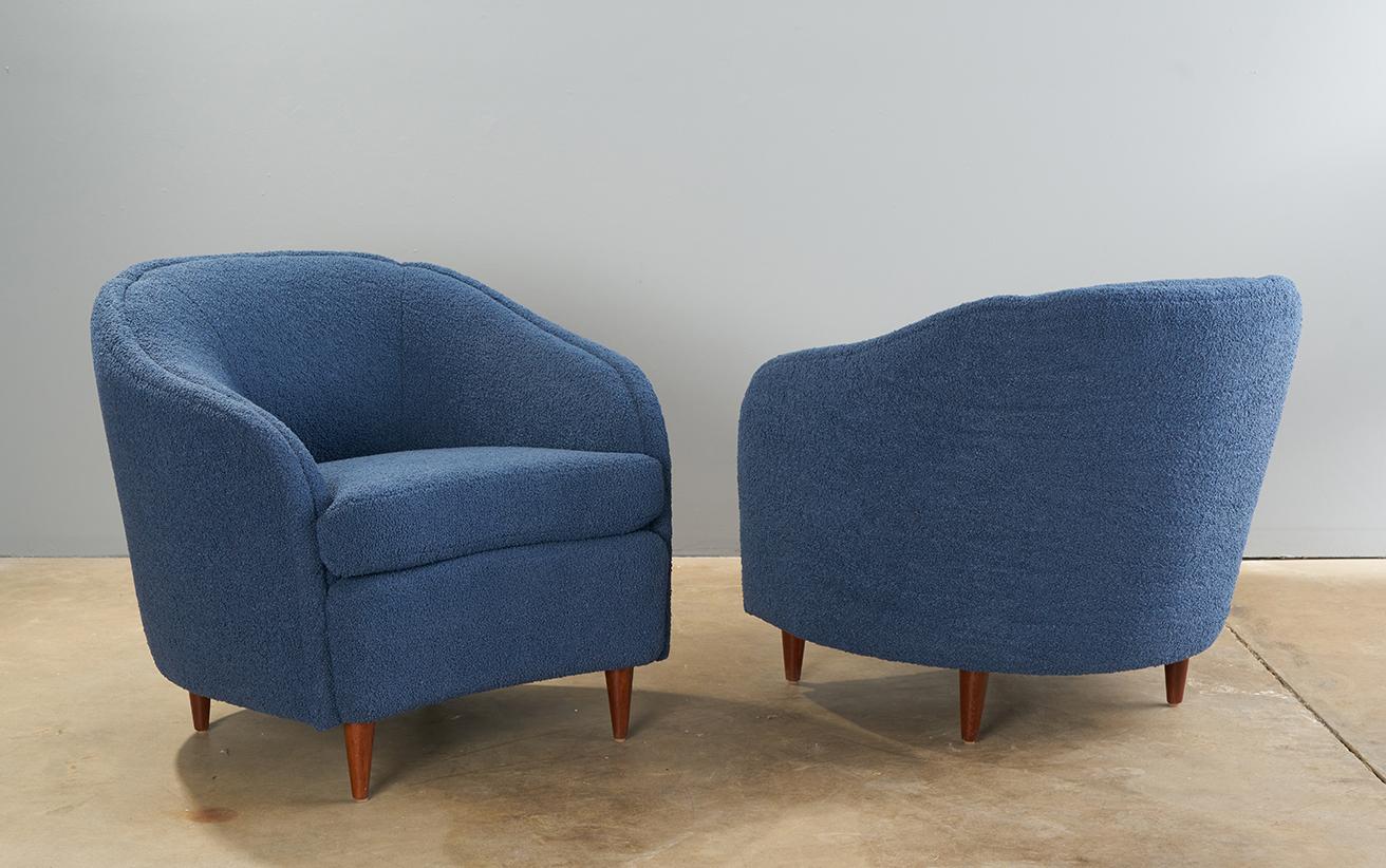 Pair of late 1940s to 1950s Italian tub chairs. Reupholstered in a denim blue boucle, with new foam. Refinished legs in a dark walnut tone. 
Exceedingly comfortable. 

Seat interior width is 20”, seat interior depth is 21”