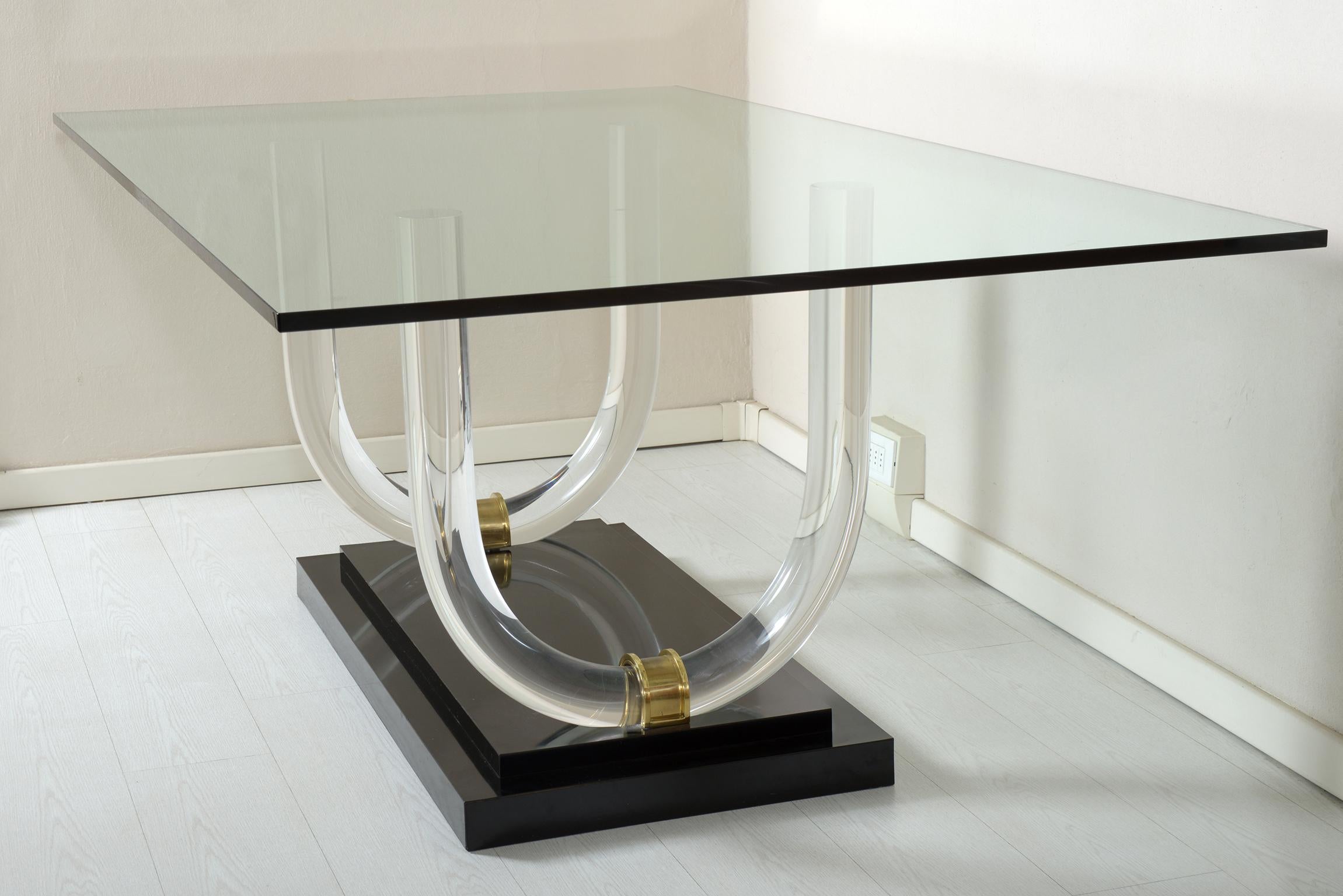 Italian midcentury 1970 rectangular table, black square base with two U-shaped Lucite elements joined together with details in cast bronze, supporting a rectangular top in thick beveled glass.
 