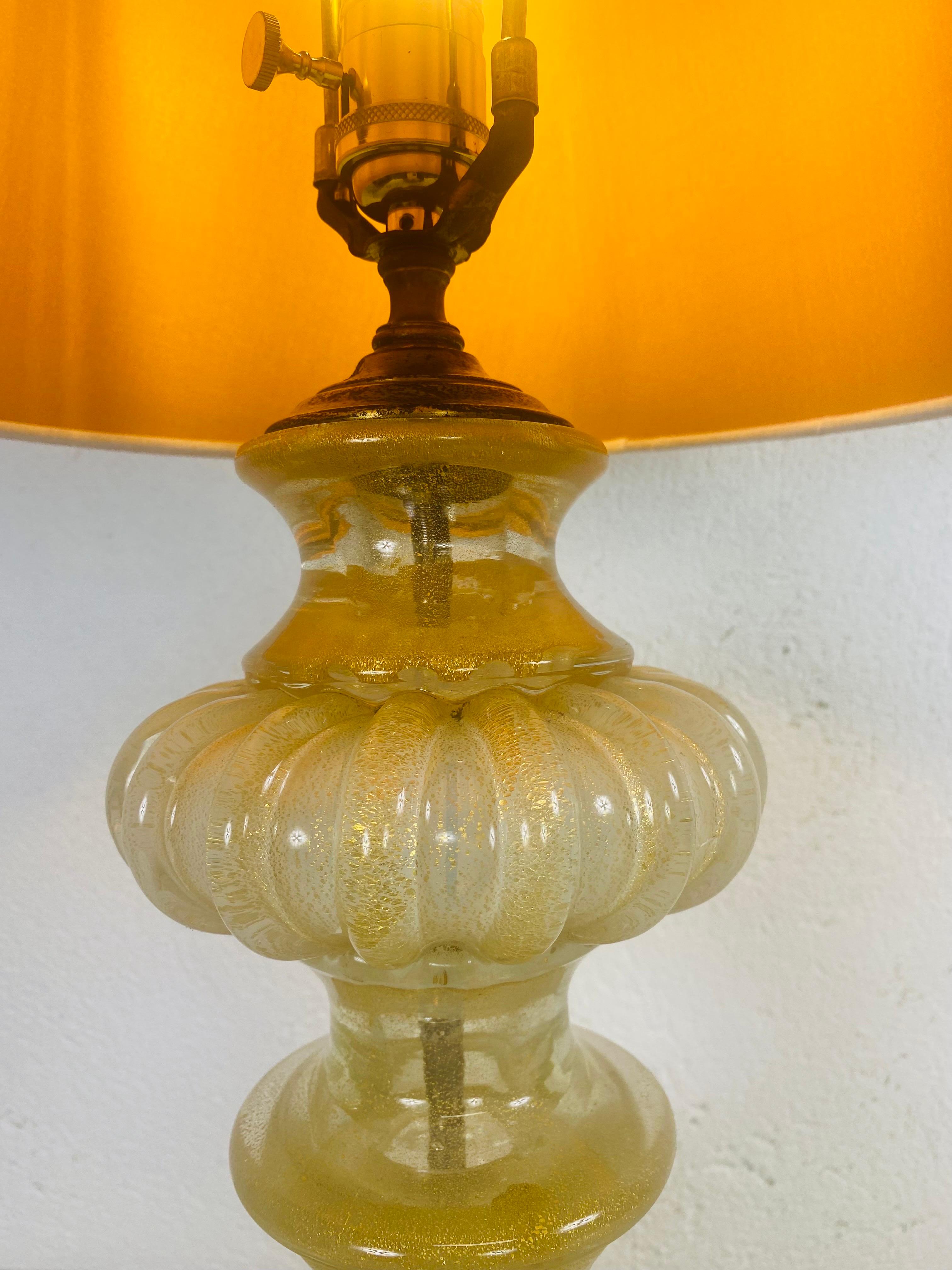 This is a stunning Italian Marano 24 karat gold fleck lamp by Barovier & Toso. This amazing Handblown Italian Marano lamp has a gold leafed Asian inspired base.The lamp is presented with a new linen shade with an amber undertone that complements the