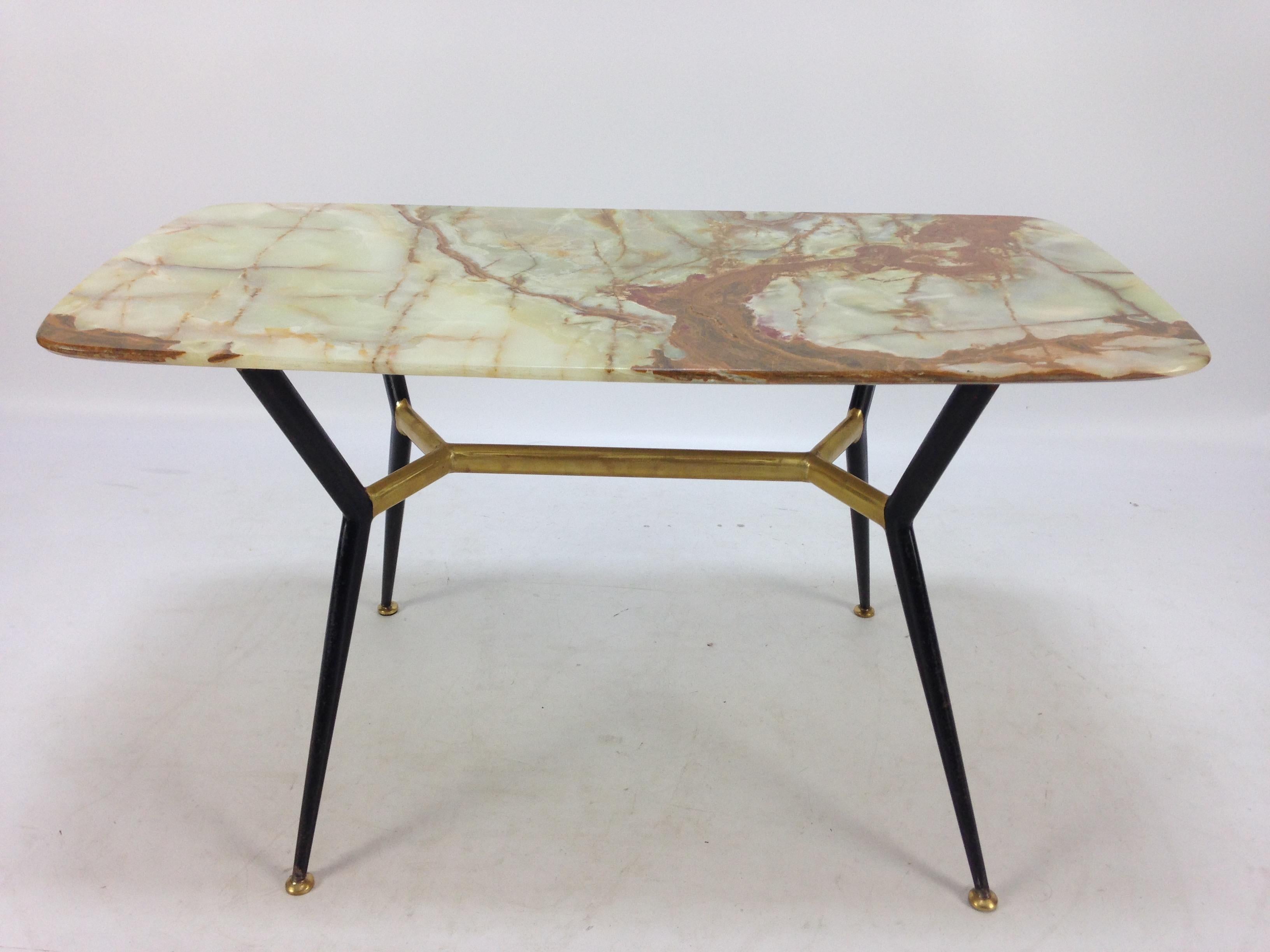 Beautiful coffee table with gorgeous elegant marble top and metallic legs with brass tips. Made in Italy during the 1950s. The marble has a beautiful natural design with mineral veins of different color and size, rare to find in such a great