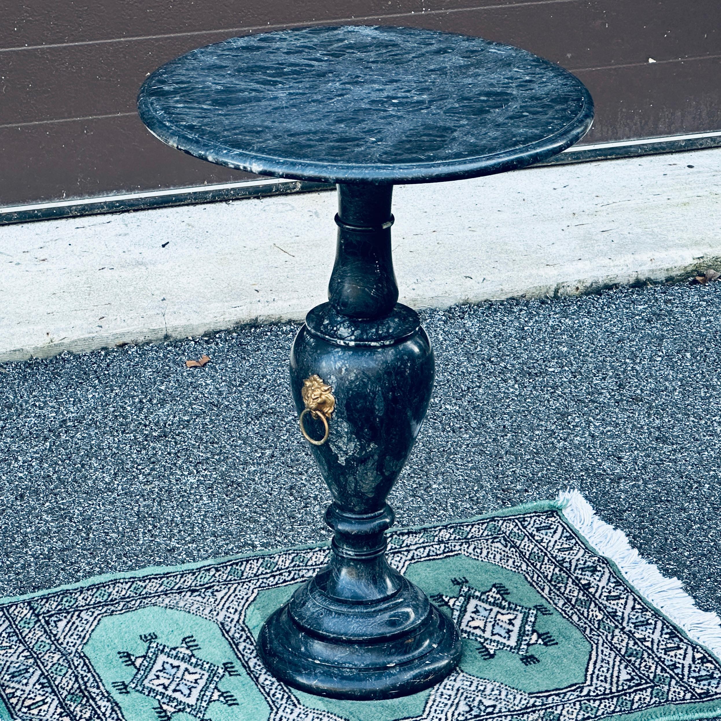 Table à boire ou support à plantes en marbre italien du milieu du siècle, avec anneau décoratif en laiton en forme de tête de lion.
Le marbre est principalement gris foncé avec des veines plus claires.
Veuillez indiquer votre code postal pour