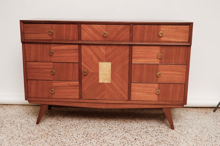 Versatile mid-century Italian sideboard or dresser beautifully crafted in a patchwork marquetry of European walnut and exotic wood veneers with brass draw pulls and goatskin inlay on the center door.

