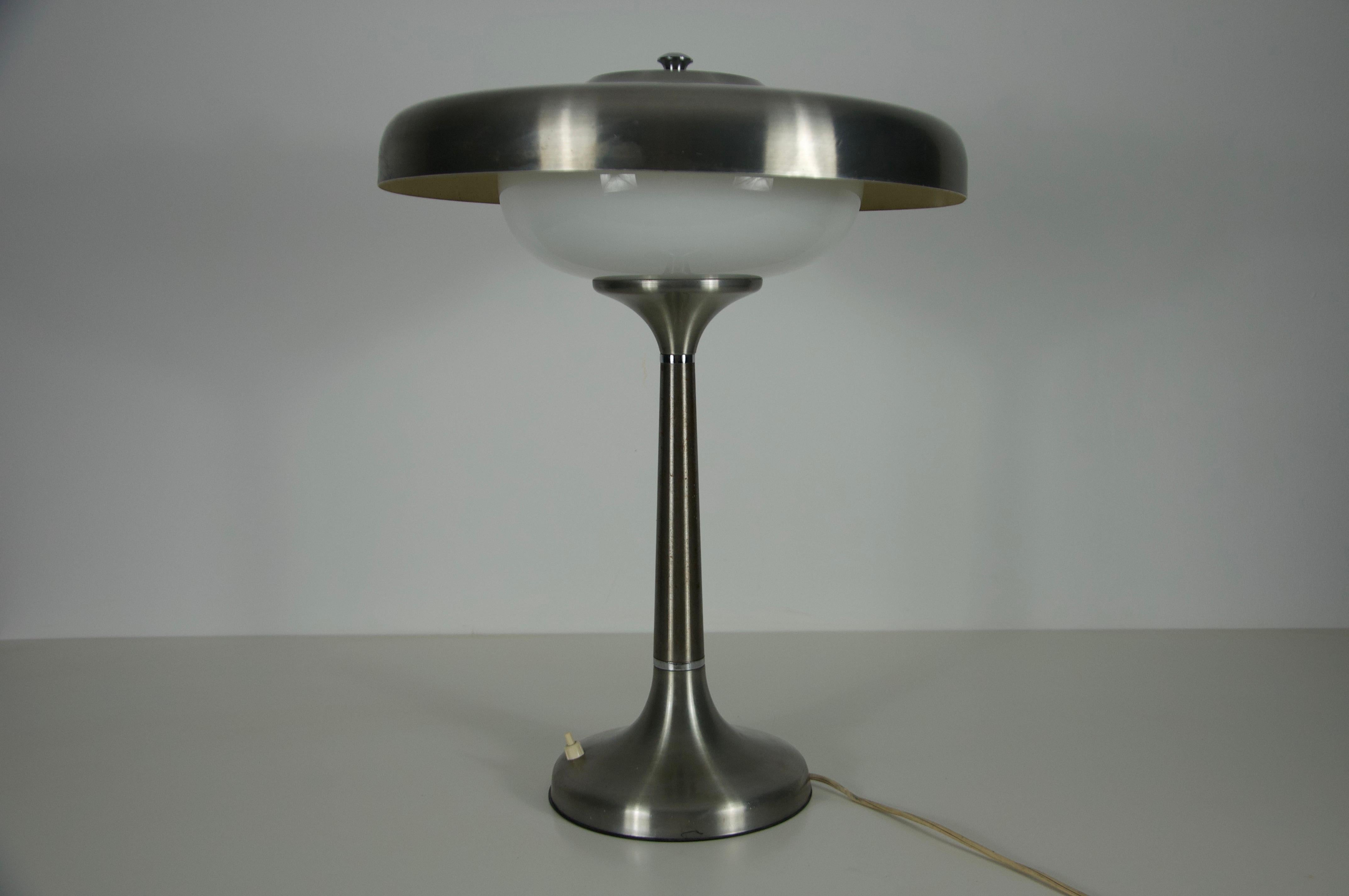 Cette élégante lampe de table italienne du milieu du siècle dernier, datant des années 1960, est un exemple frappant de design moderniste, alliant des matériaux raffinés à un style intemporel. La pièce se compose d'une base et d'une tige en métal