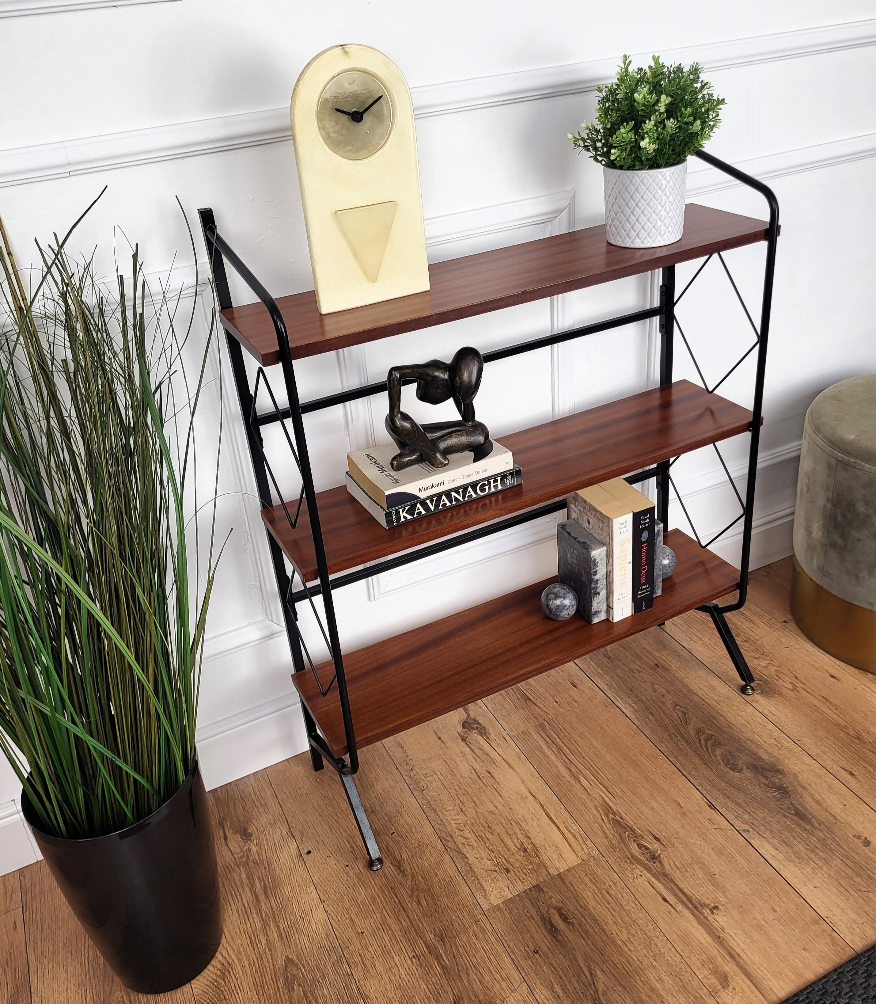 A beautiful Italian open bookcase bookshelf with a black metal structure, walnut shelves and brass details. Materials and shape are in typical Mid-Century Modern style. A very elegant, modern and classic piece.
