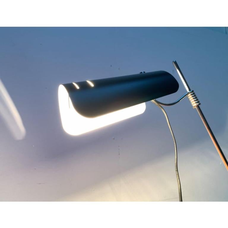 Mid Century table lamp from Italy.

A minimalist design with a special base. The reflector head is made of a barrel-shaped sheet metal, finished in black on the outside and white on the inside. In the front area there are two slots. The head is