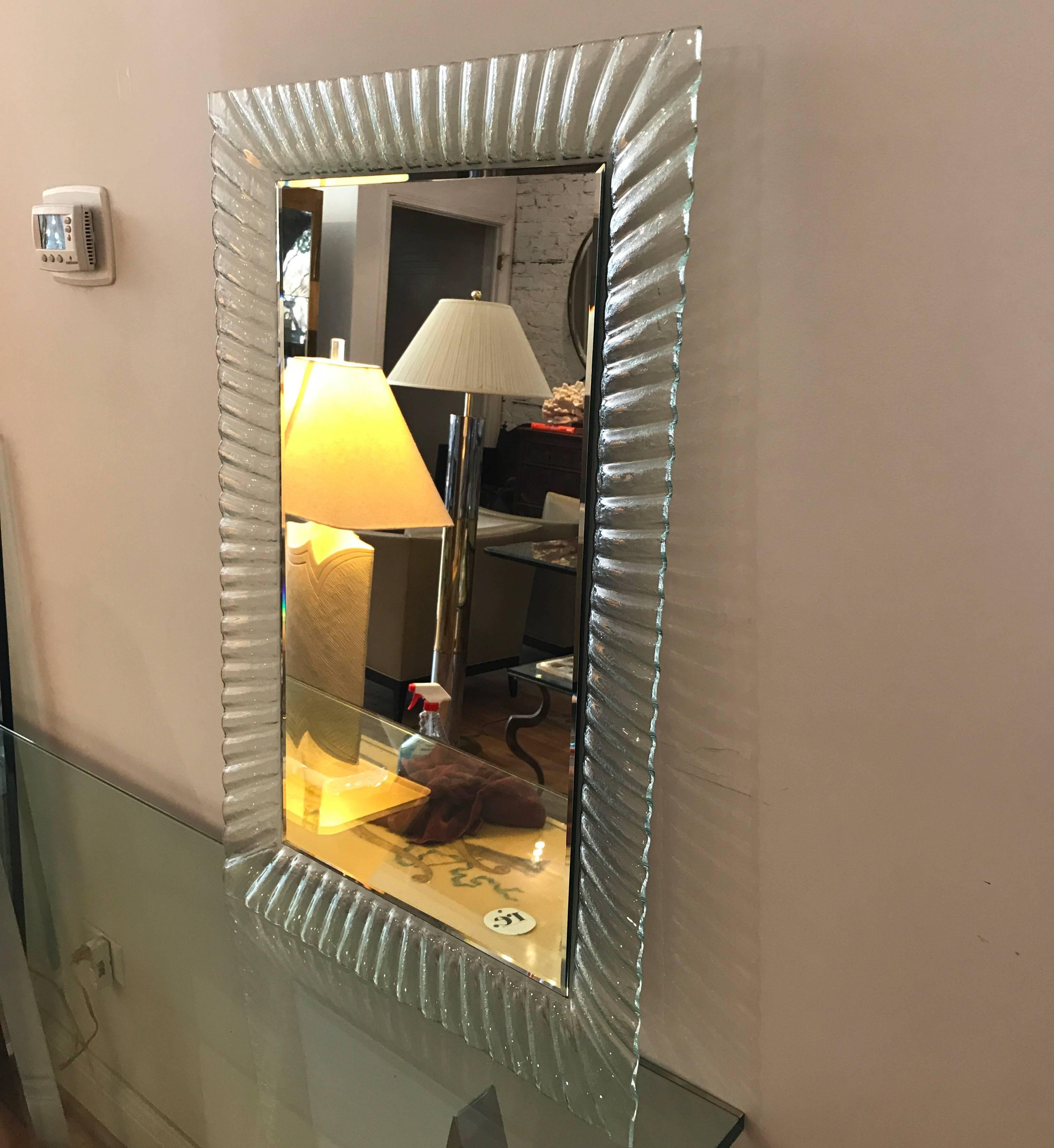 An elegant Italian mirror with a fluted clear Murano glass frame. The fluted alternating clear and frosted frame and back of the mirror is one solid piece.
See images. May be hung vertically or horizontally.