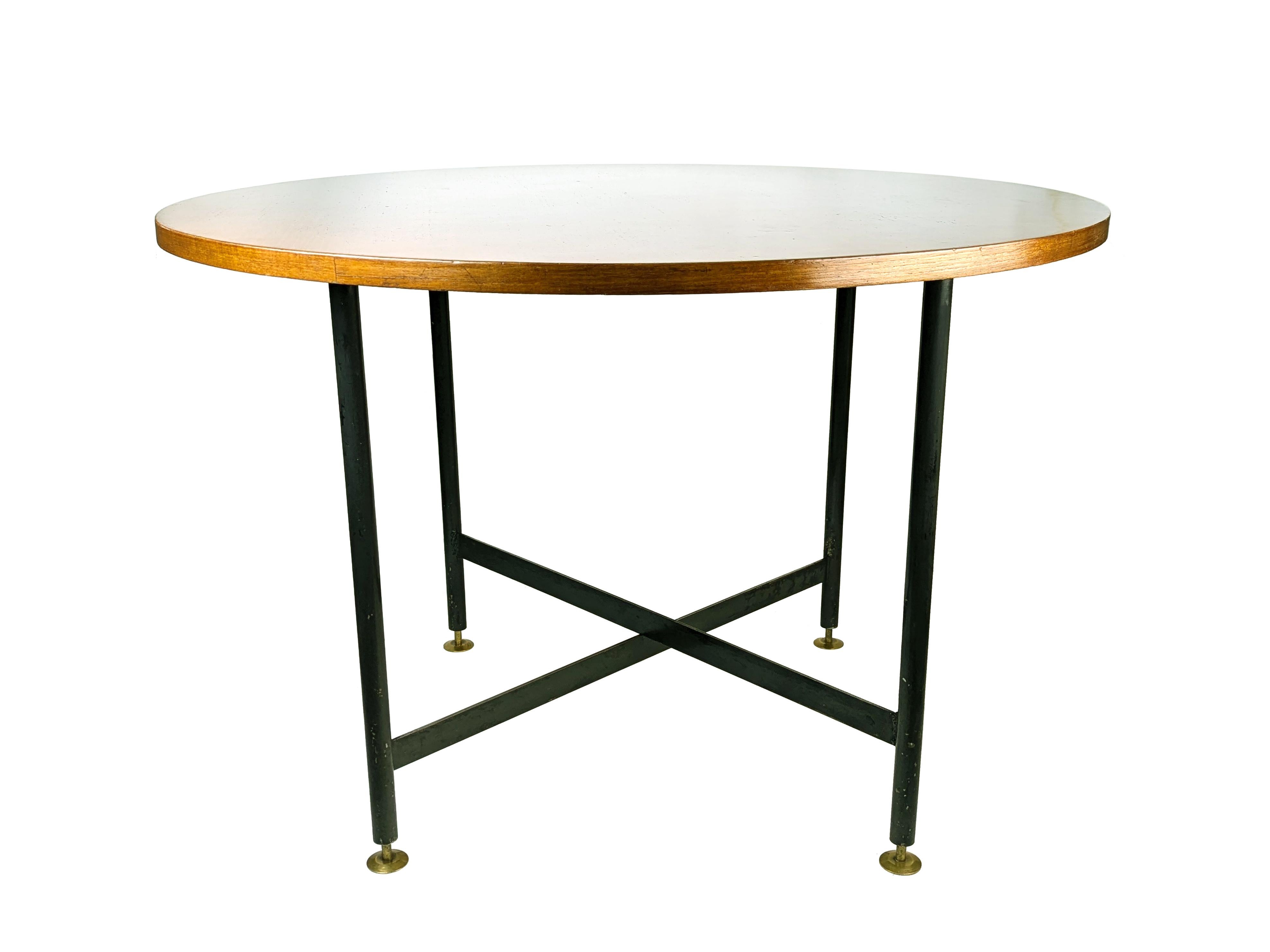 Round dining table made in Italy in the late 1950s. Top in teak wood. Black iron legs with brass feet. 
The table top has been restored; the black painting of the legs is original but there are visible oxidation stains and losses. 
For optimal