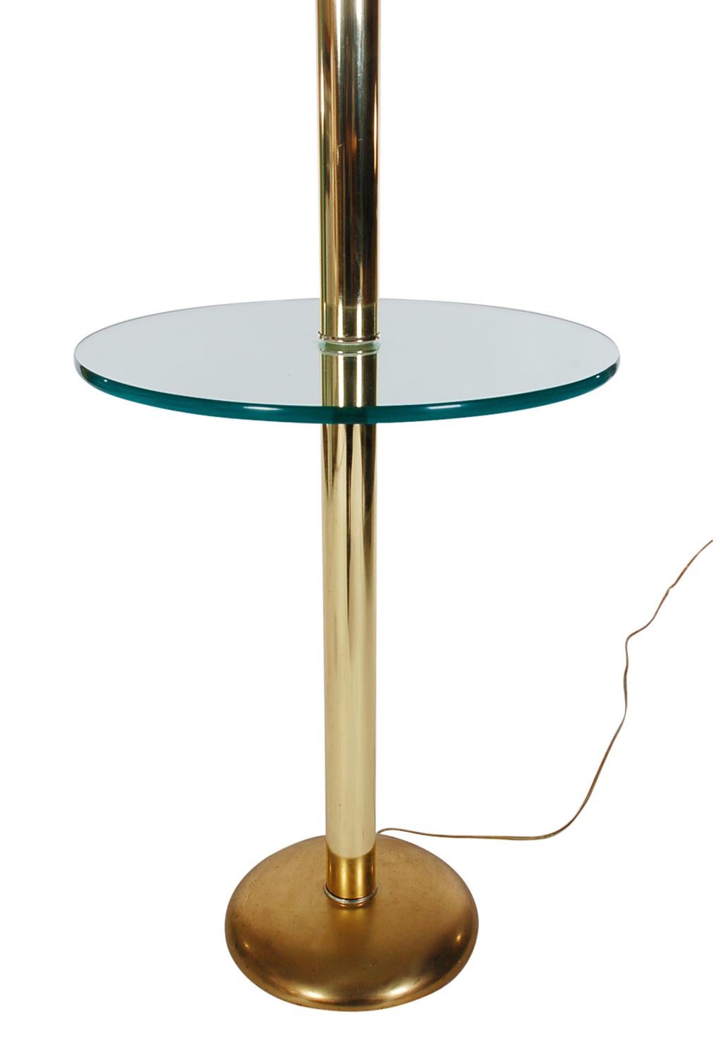 A fine quality floor lamp with round glass table from Italy circa 1982. The lamp features brass plated steel construction, clear glass circular table insert, and thick Lucite rings. Tested and working.