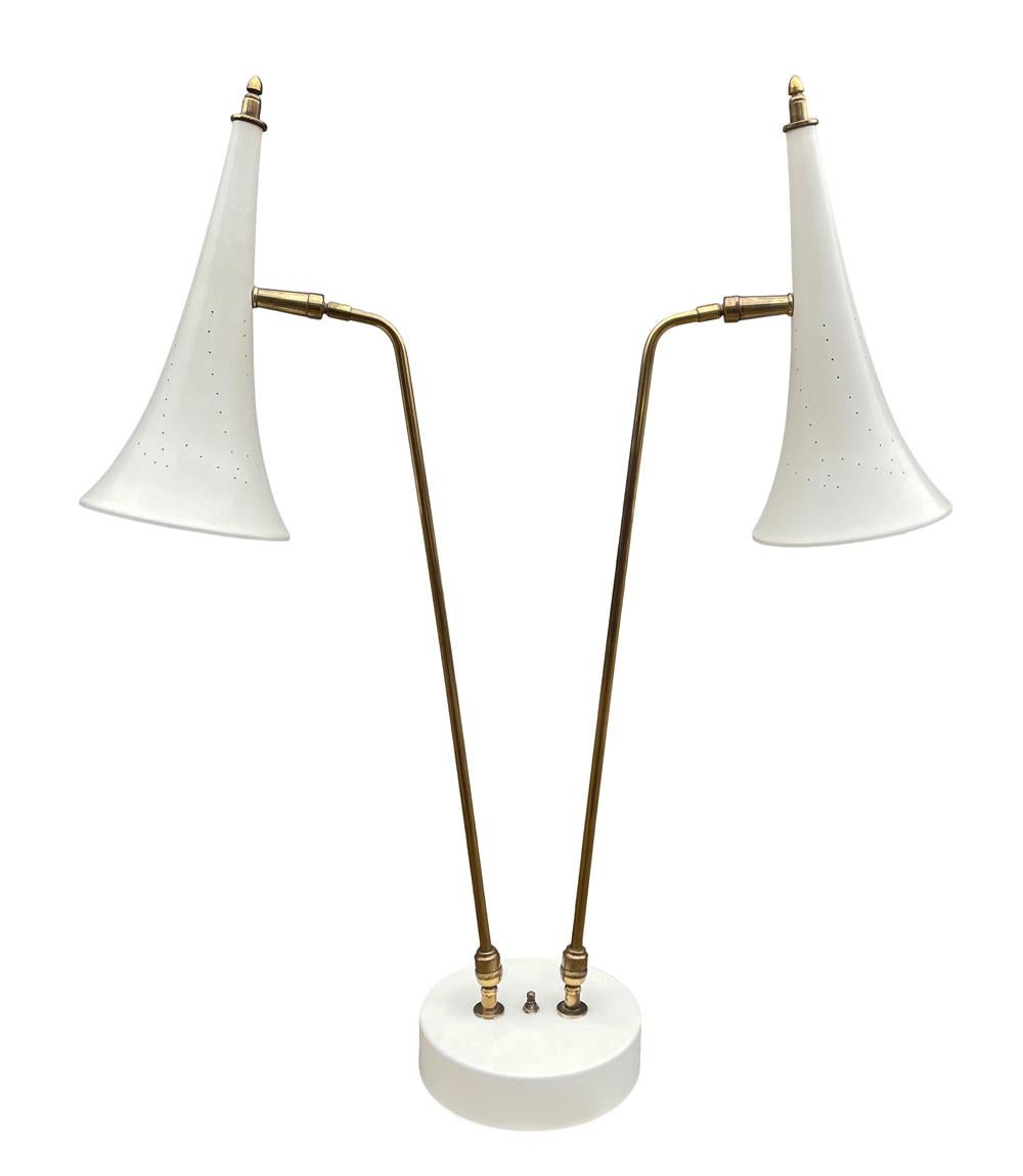 A sleek vintage table lamp attributed to Stilnovo circa 1960's. This fully articulating lamp features white enameled shades with brass elements. In amazing vintage condition. Measurements are for main photo. Lamp is fully adjustable.