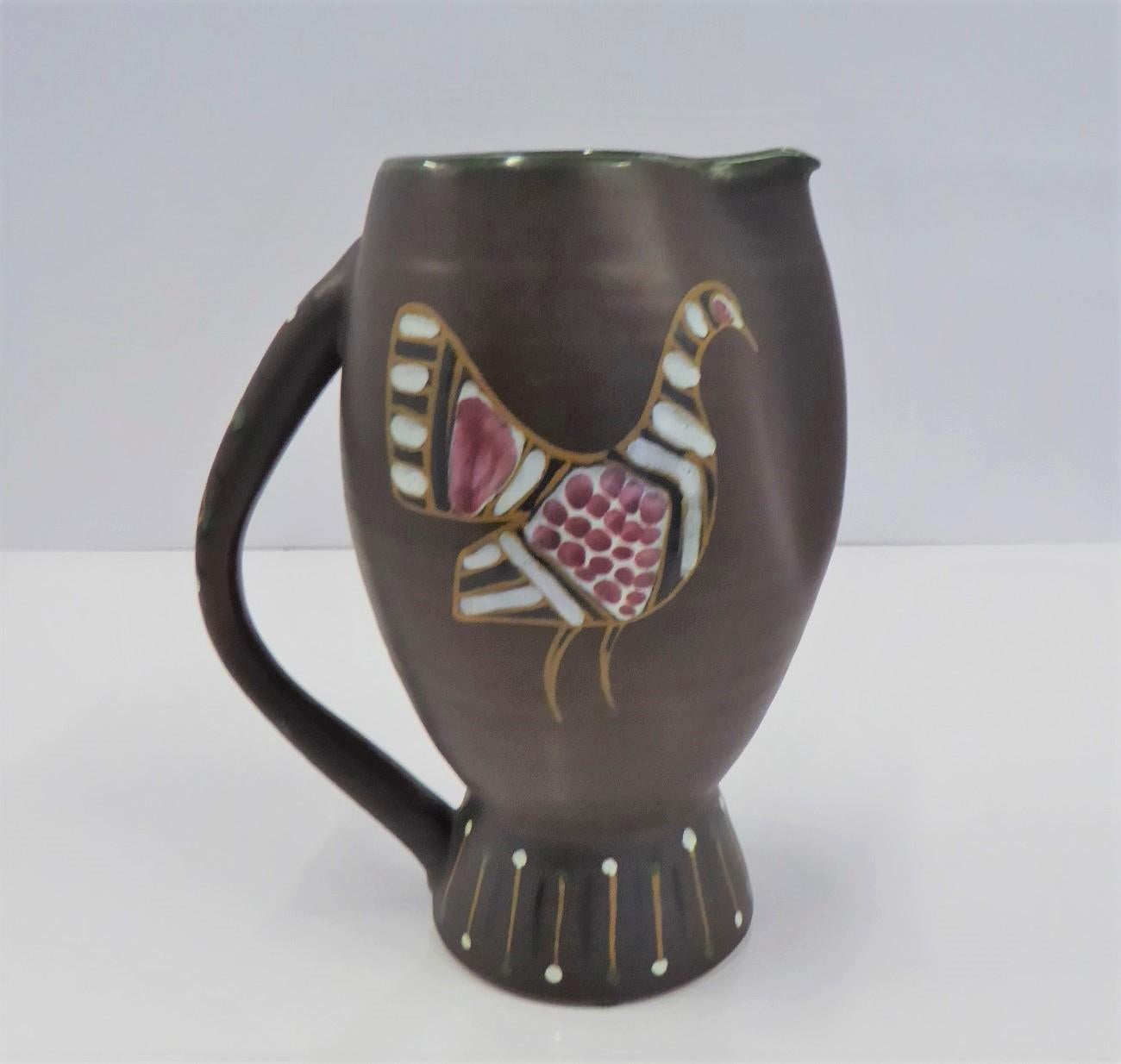 Mid-Century Modern Italian pottery pitcher vase made by Fratelli Fanciullacci in the early 1960s. With a matte brown glaze on the body and glossy decoration. of a Guinea Fowl and a Swan. The handle is decorated with a geometrical design in yellow,