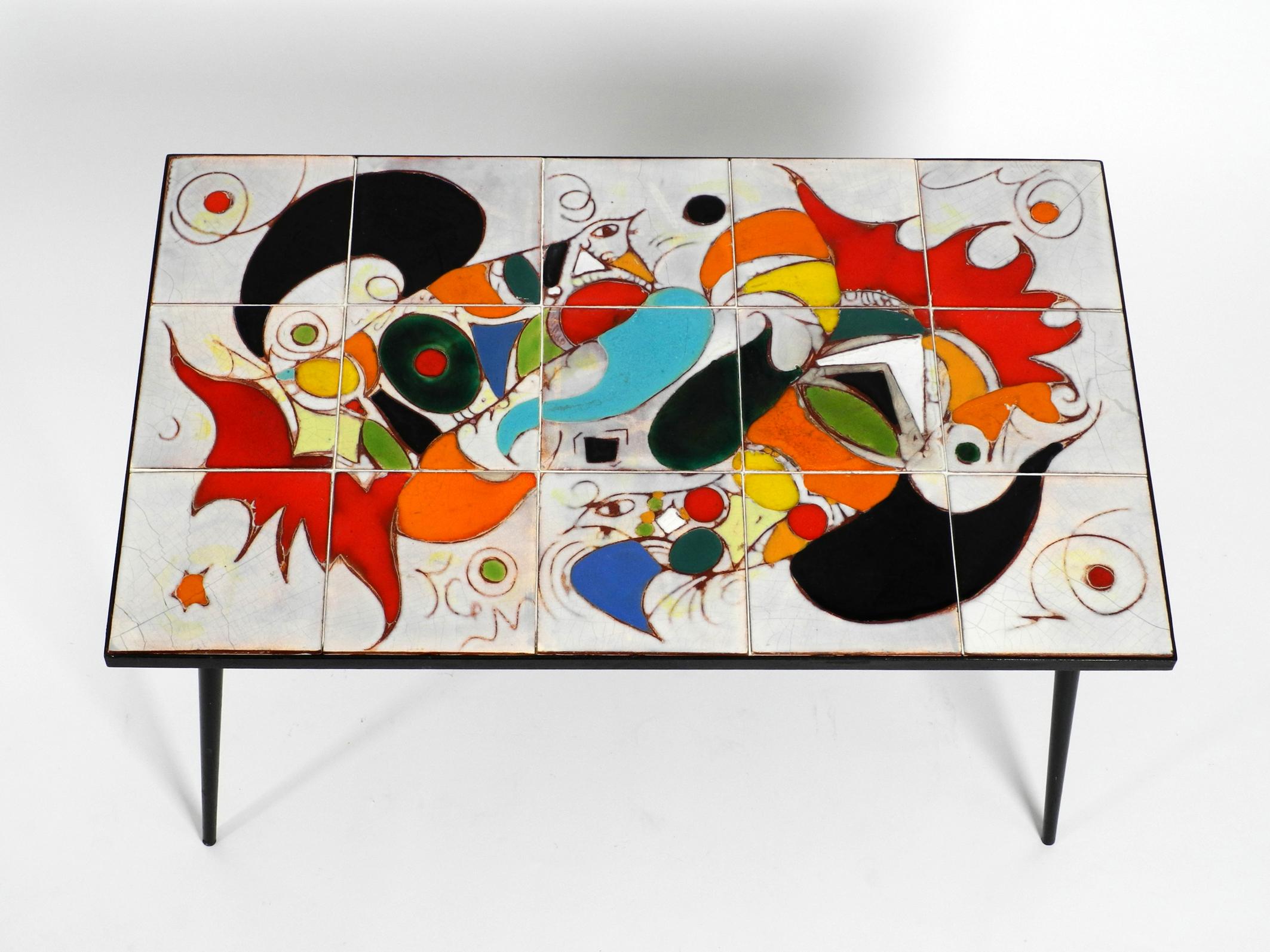 Beautiful very rare Italian Mid-Century Modern coffee or side table with frame
made of black painted iron. The tabletop consists of a wooden plate covered
with a colorful abstract motif consisting of 15 ceramic tiles.
Made in Italy. Manufacturer