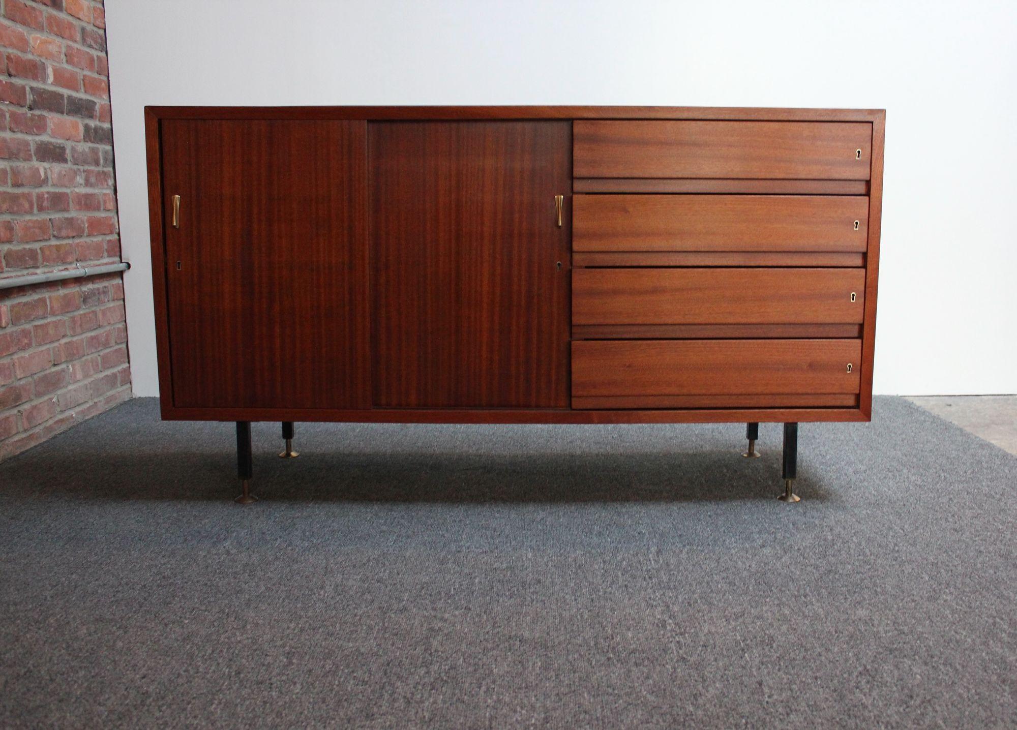 Italienische Vintage-Credenza aus Mahagoni mit himmelblauer Laminatoberfläche, geschnitzten Messinggriffen und verstellbaren Messingfüßen (ca. 1960er Jahre, Italien). 
Besteht aus vier verschließbaren Schubladen und zwei Schiebetüren, die sich