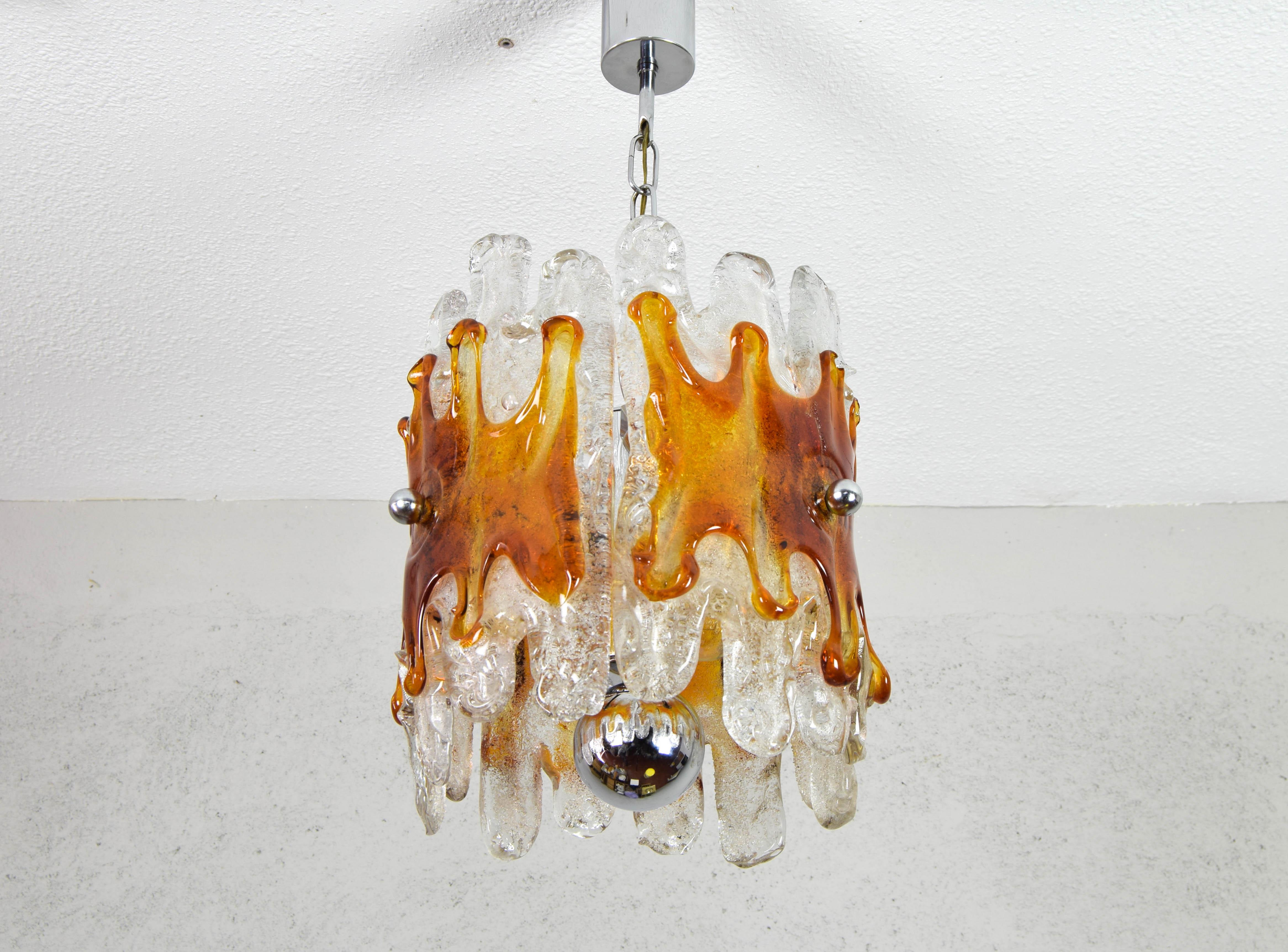 Kronleuchter aus Murano-Glas, hergestellt von Mazzega in Italien in den 1960er Jahren.
Verchromter Stahlkörper mit drei Leuchtmitteln für E14-Glühbirnen, die unten von einer verchromten Stahlkugel abgeschlossen werden. In jedem der drei Arme ist