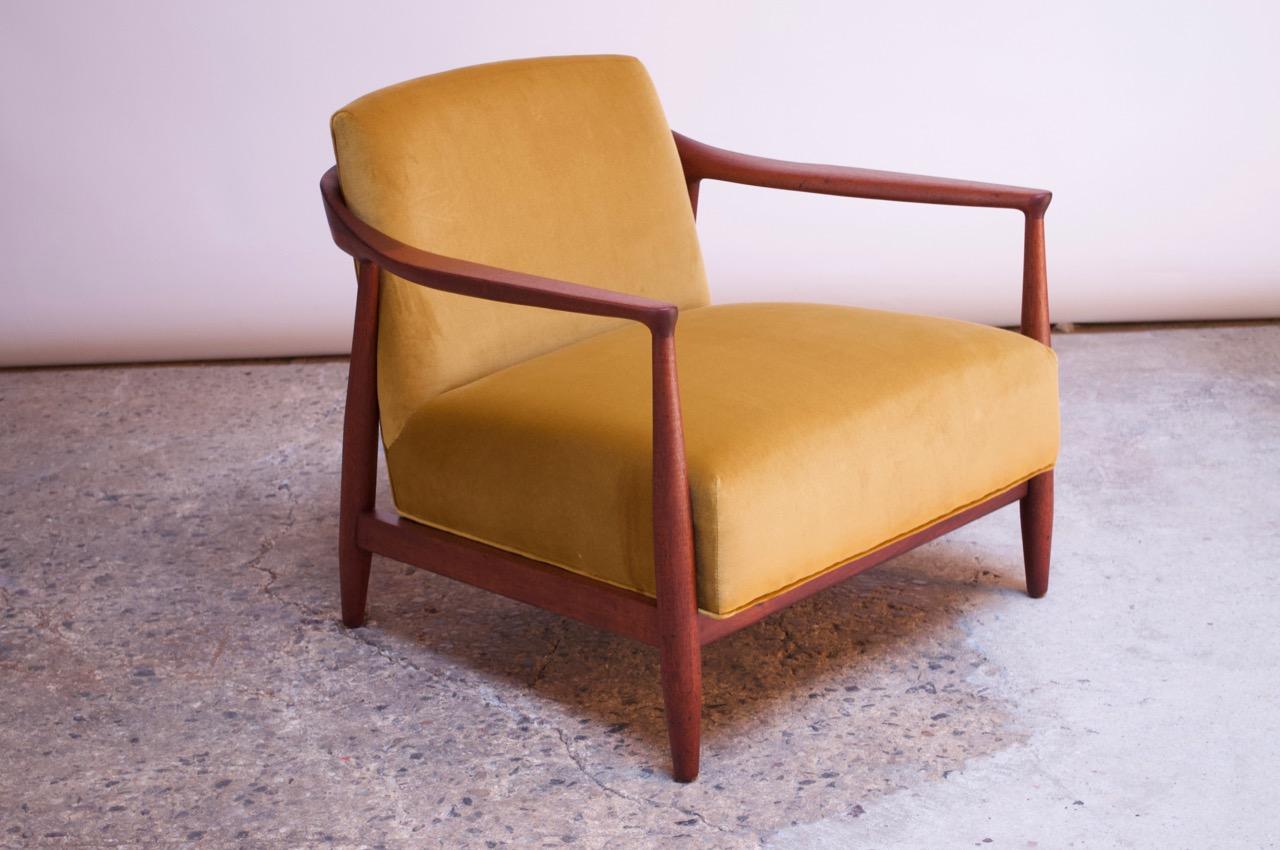Striking, diminutive 1950s Italian lounge chair featuring a sculpted walnut frame and continuous back / seat cushion. Relatively low but wide profile, offering comfort while maintaining a small footprint. Newly reupholstered in an ochre velvet with