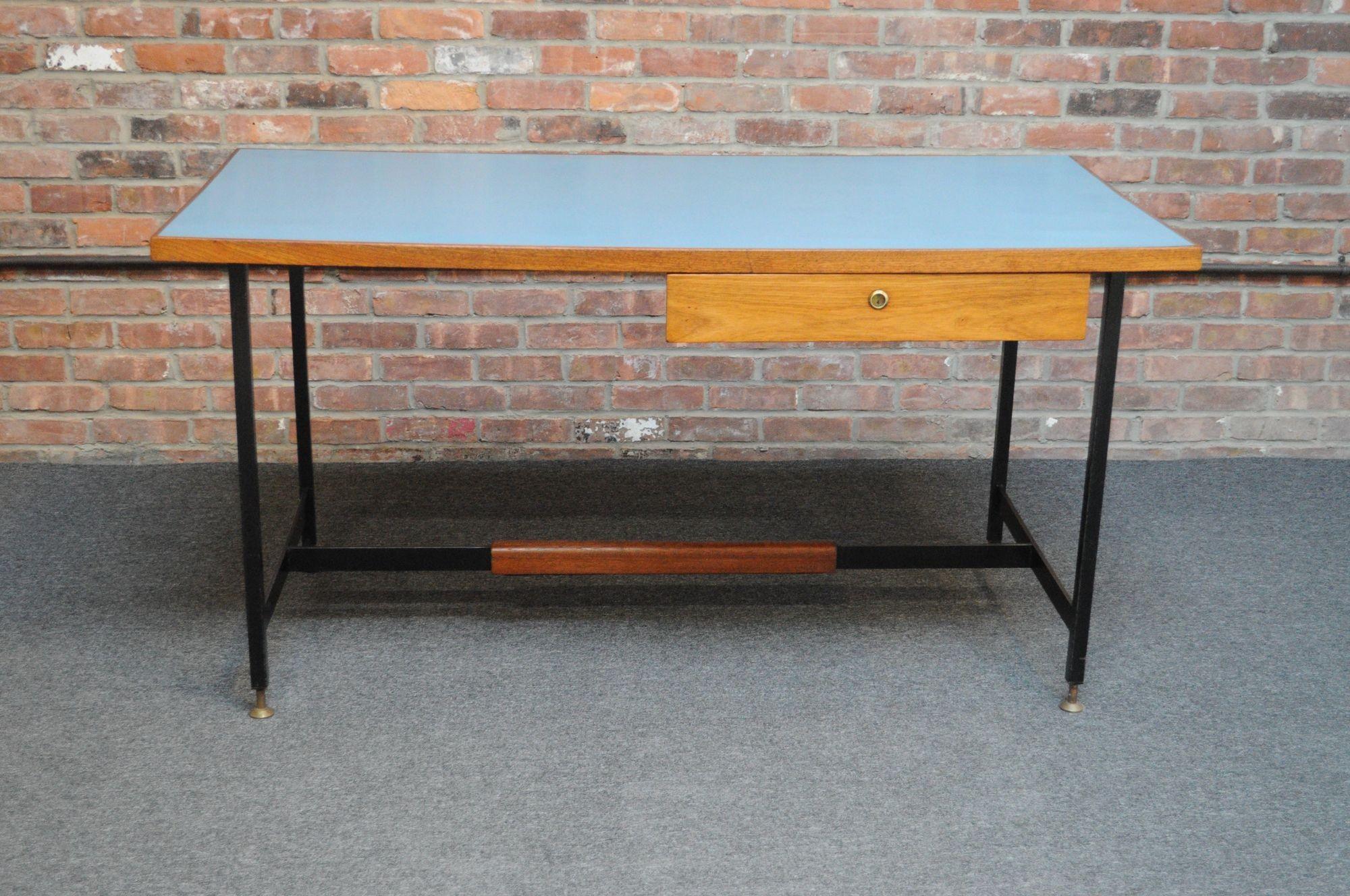 Single-drawer desk composed of a light blue laminate surface with walnut trim, drawer and foot rest, all supported by a black steel base with patinated brass, adjustable feet (ca. 1950s, Italy).
Well designed and crafted with dovetail details and