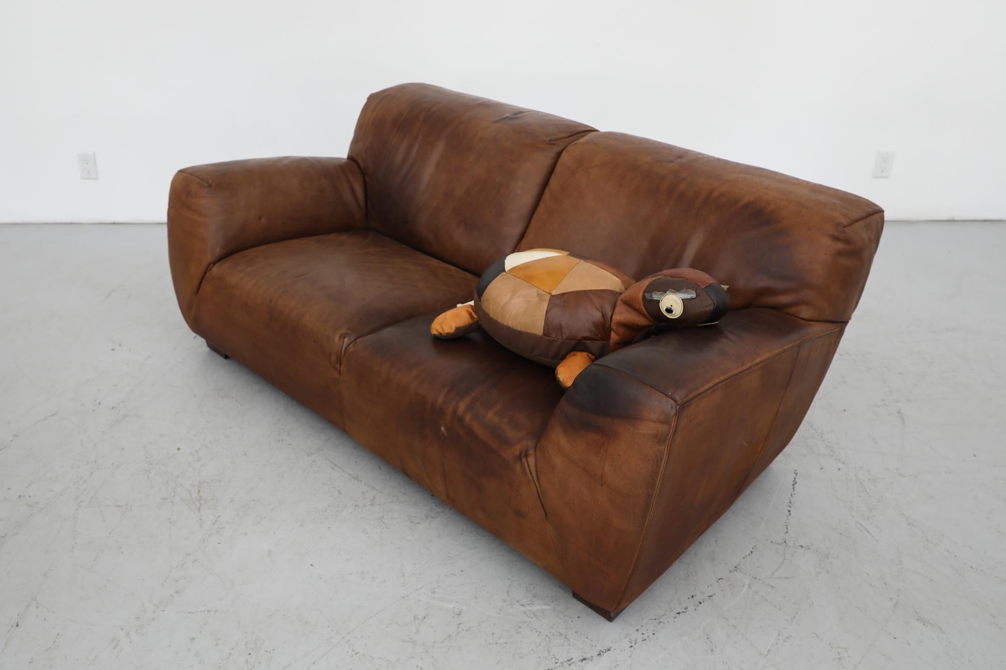 Midcentury thick cognac leather loveseat by Molinari Design, Italy. Time has added a beautifully rich patina to the piece: It is in original condition with high end thick and durable leather showing age appropriate signs of wear including some