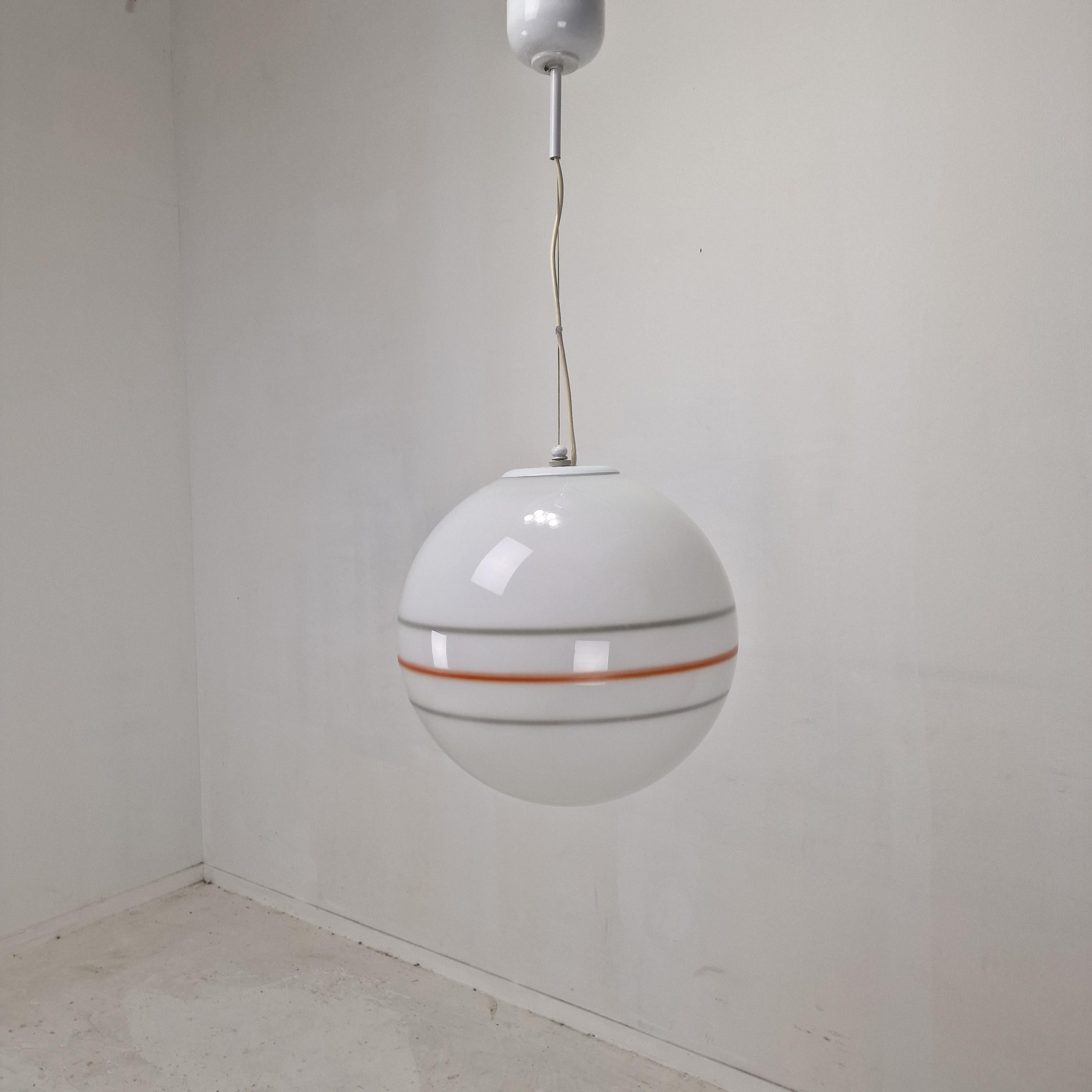 Un sorprendente lampadario Globe di stile Mid-Century Modern realizzato in Italia negli anni Settanta.
Vetro di Murano soffiato a mano sospeso da una cornice elegante. 
Il globo è realizzato in vetro opalino di Murano e offre una luce morbida e