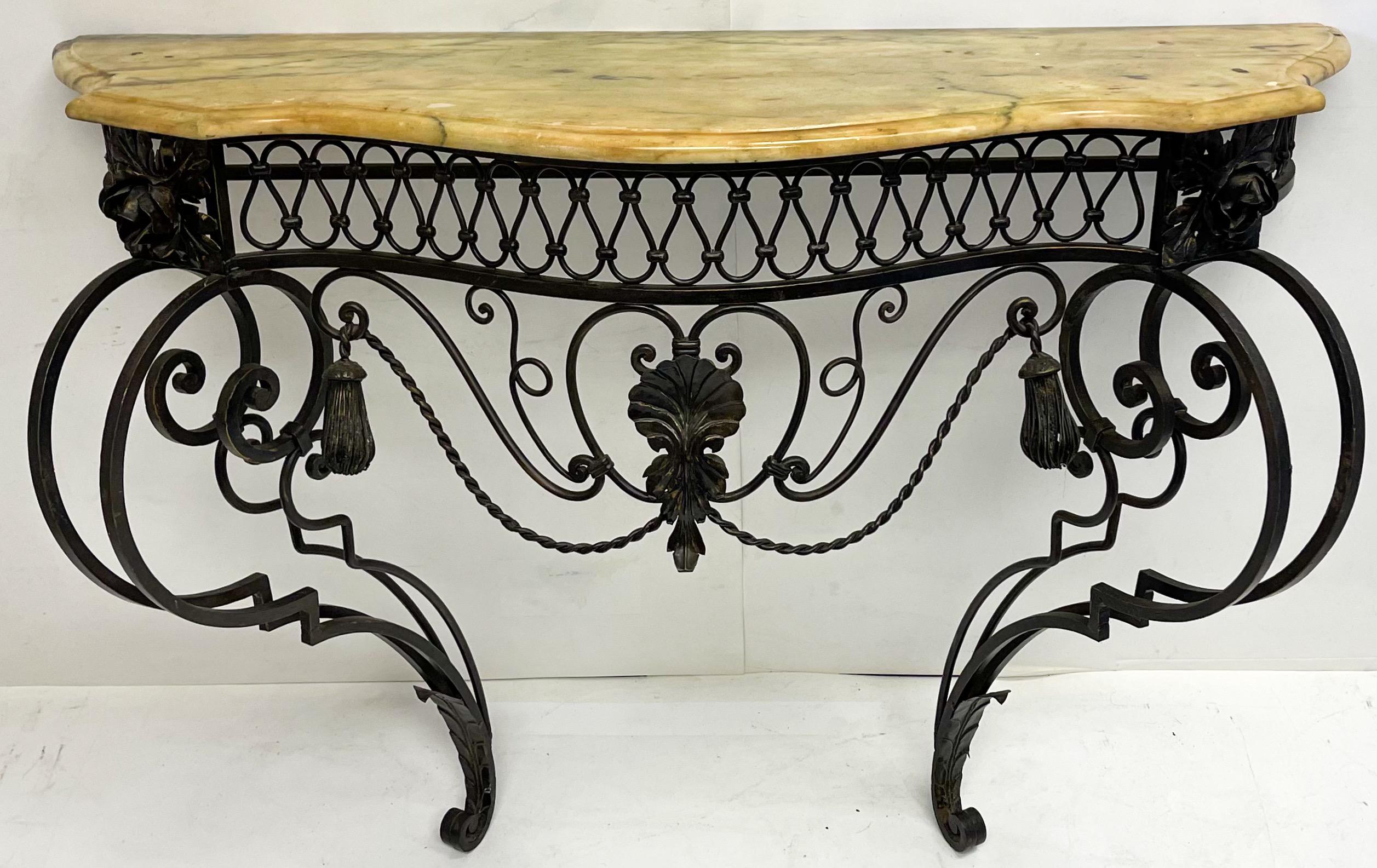 This is a mid-century Italian neo-classical style iron and marble top console table. It is wall mounted. The elaborate scrolled iron is accented with both shell and tassels. It is in very good condition. The 15 inch depth listed below is for the