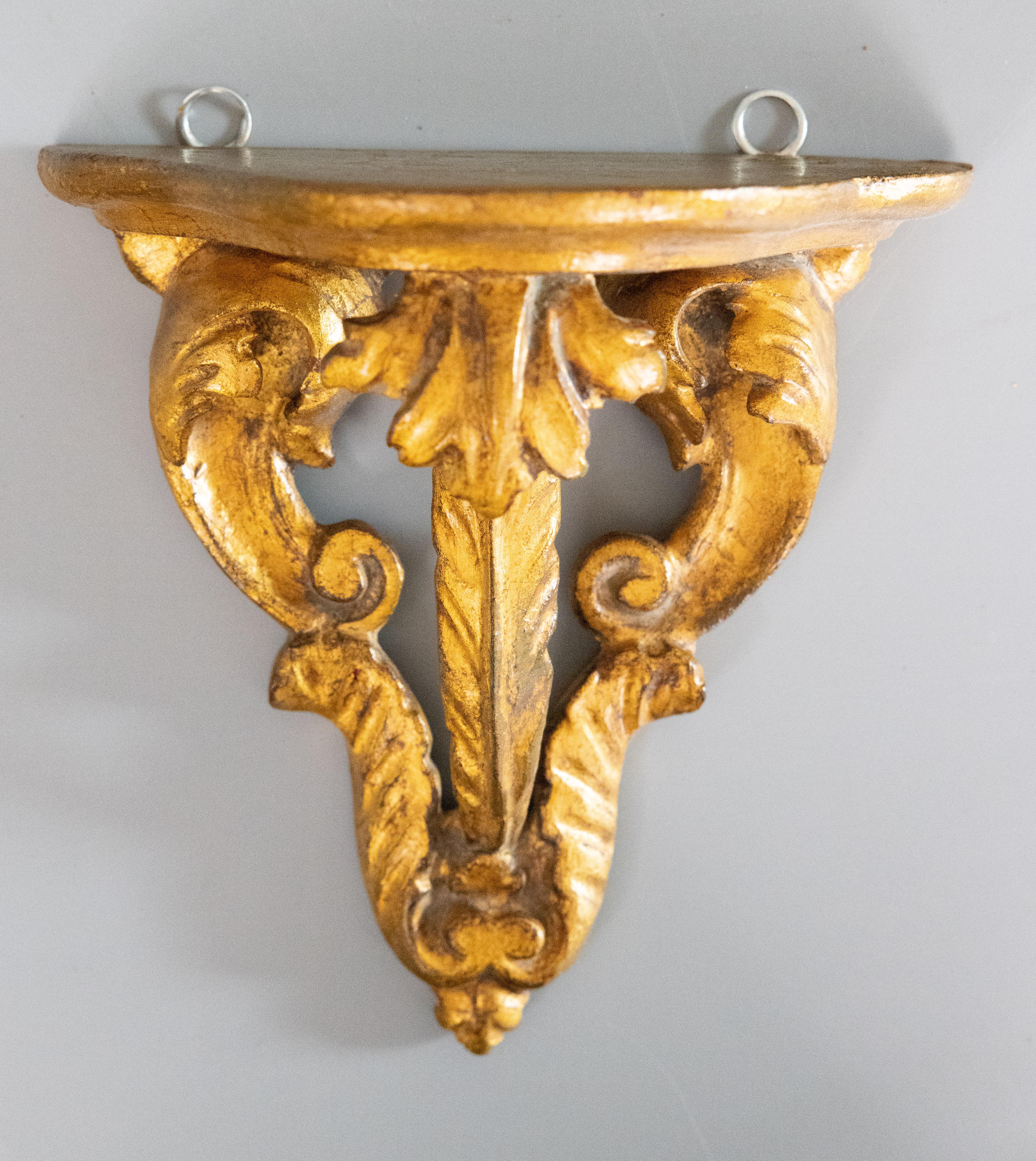 A lovely vintage Mid-Century Italian gilded wood wall bracket shelf. This stylish bracket has a hand carved scrolling acanthus leaf design and beautiful gilt patina. It's perfect for displaying decorative collectibles or fabulous on its