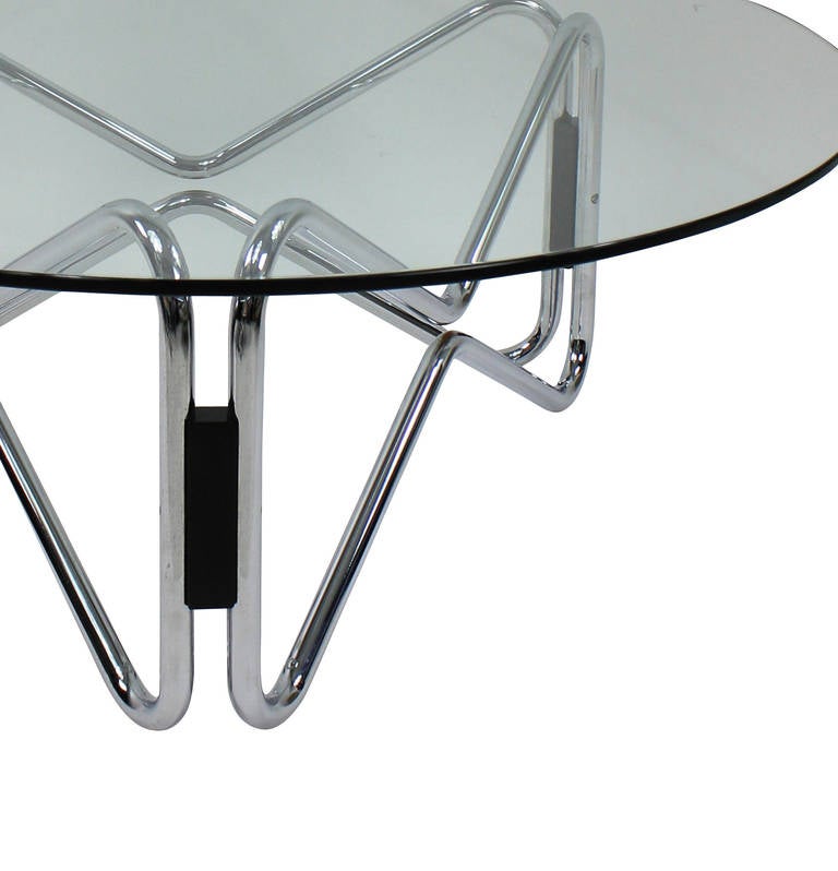 An Italian occasional table of geometric design in chrome, wood and with a circular plate glass top.
 