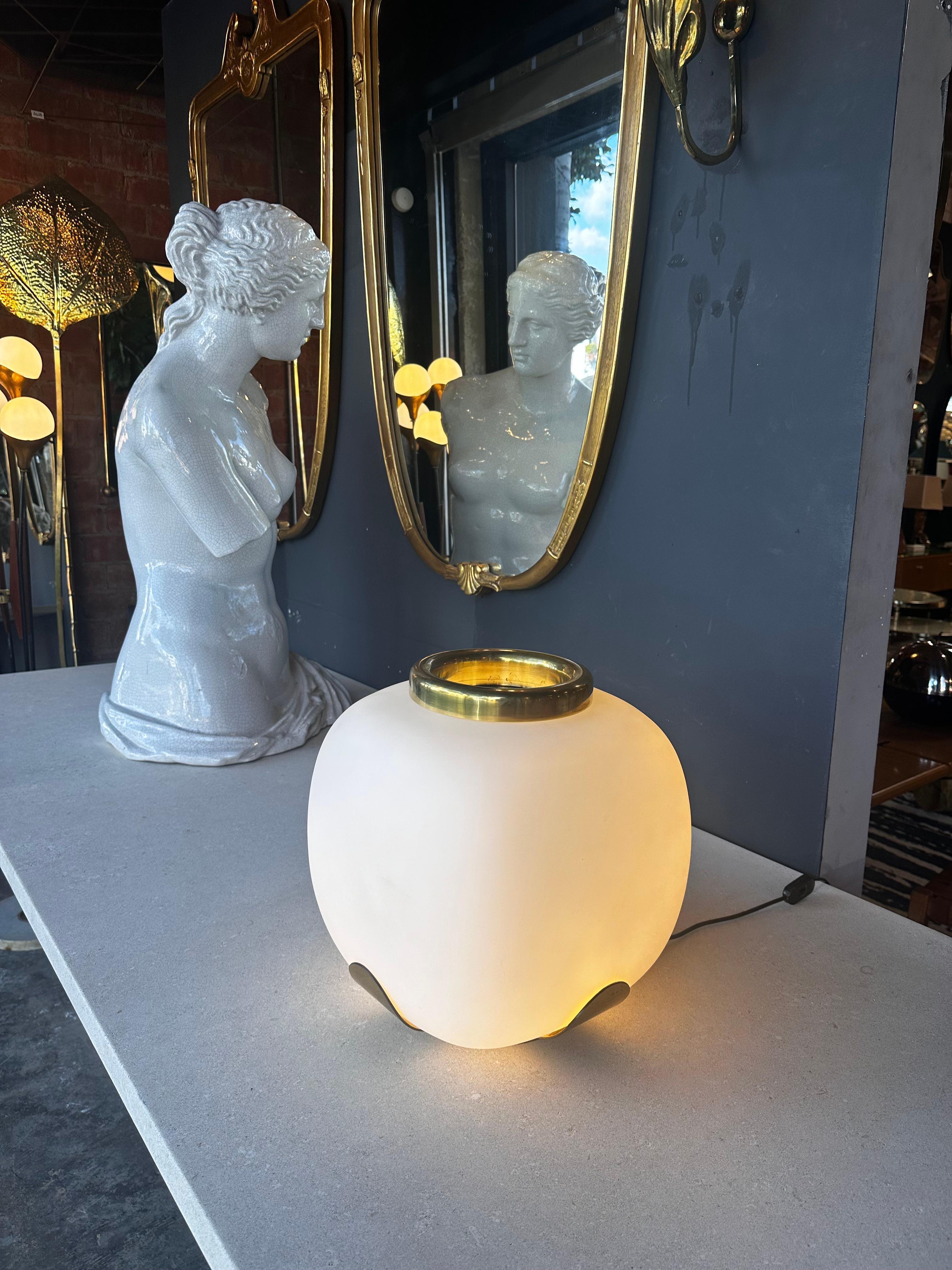 Illuminate your space with the timeless elegance of this Mid-Century Italian Opaline and Brass Table Lamp from the 1970s. The lamp exudes sophistication with its opaline glass shade, casting a soft, warm glow that adds a touch of vintage charm to