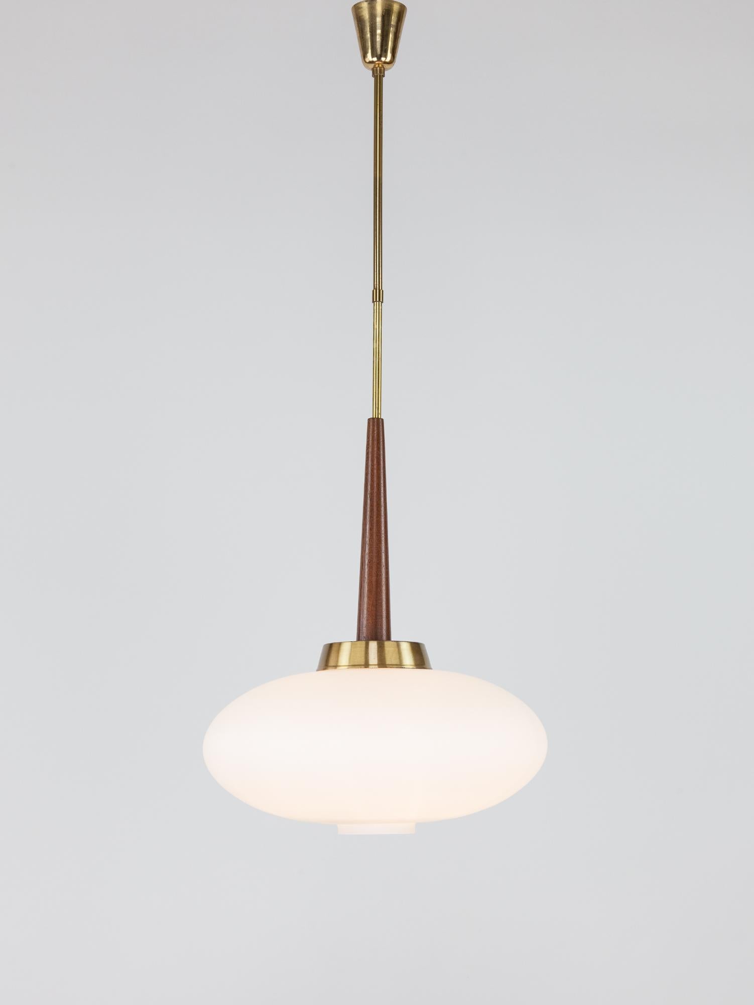 Stunning and rare vintage Italian modernist pendant. The white soft milky glass emphasizes the beautiful patina of the brass and the rich orange-brown of the teak detail. Elegant in its design, the pendant epitomizes classical Italian modernist