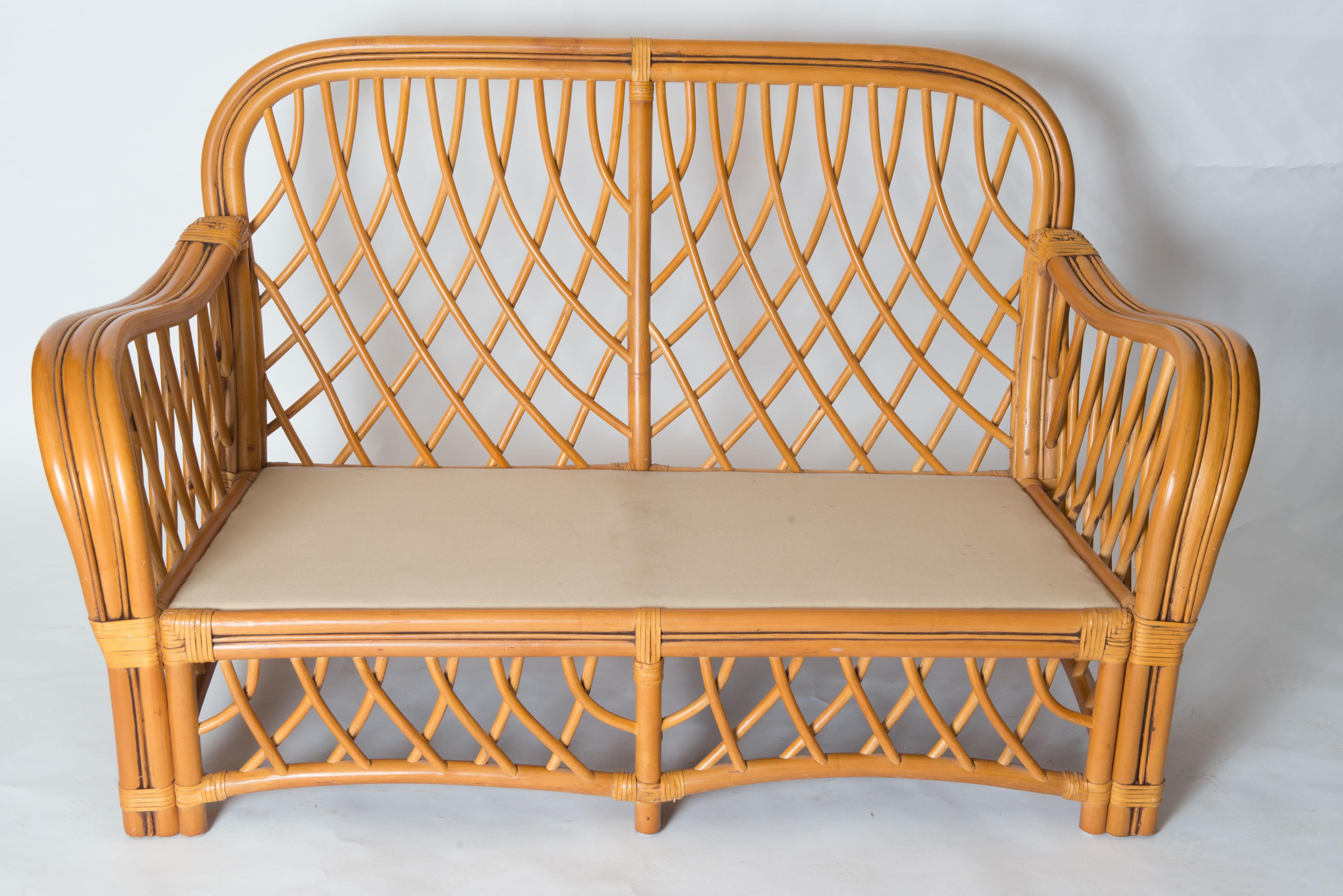 A midcentury, possibly Italian organic modern loveseat in handcrafted rattan. Strong and sturdy woven diamond pattern rattan loveseat. This loveseat is in good to excellent condition. This Classic design compliments any decorating style. There are