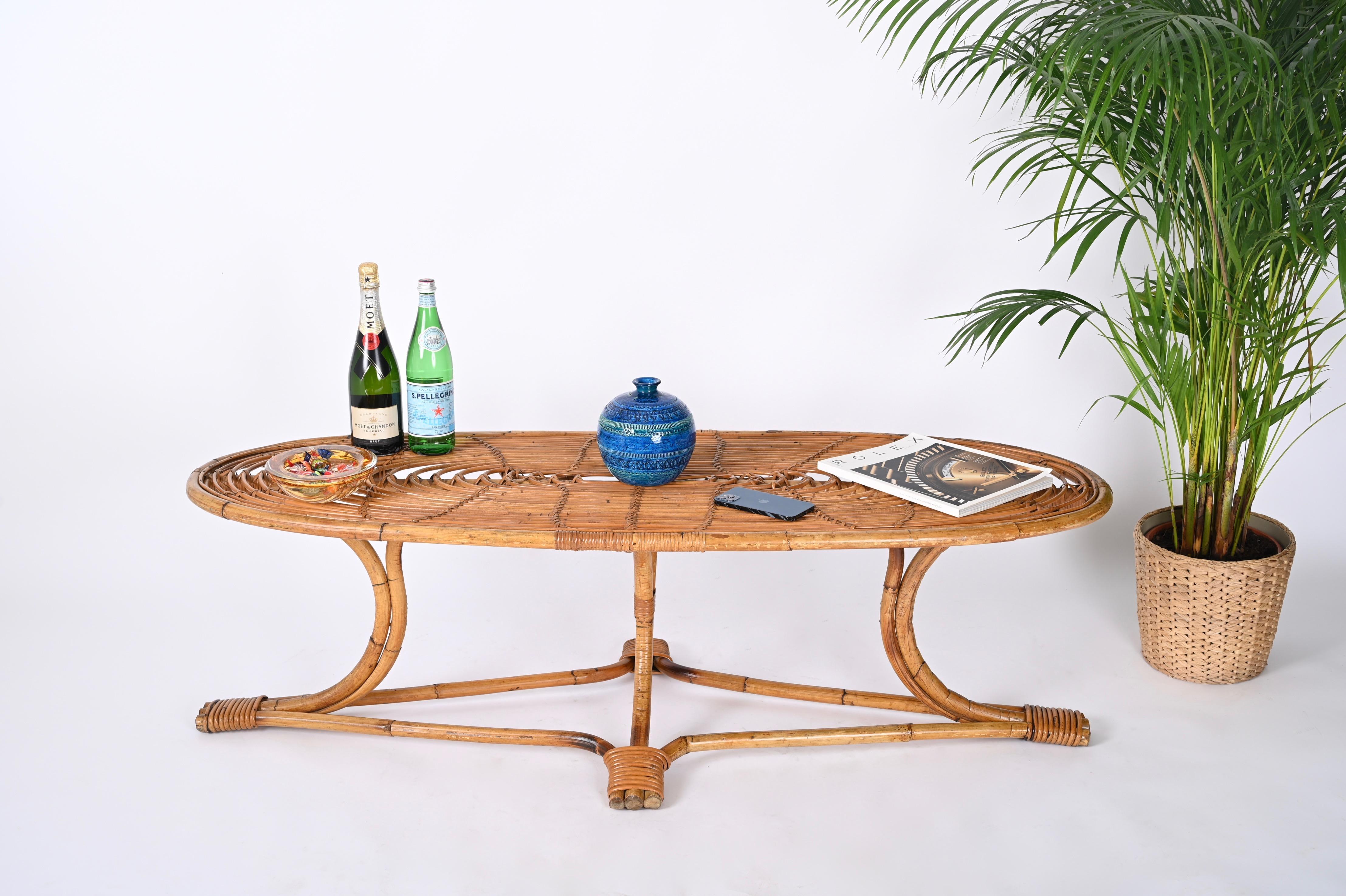 Marvellous large coffee table fully made in curved bamboo, rattan and wicker. This fantastic piece was realized in Italy during the 1970s. 

The table features a stunning base with four legs in curved bamboo kept together by thick rattan wicker. The