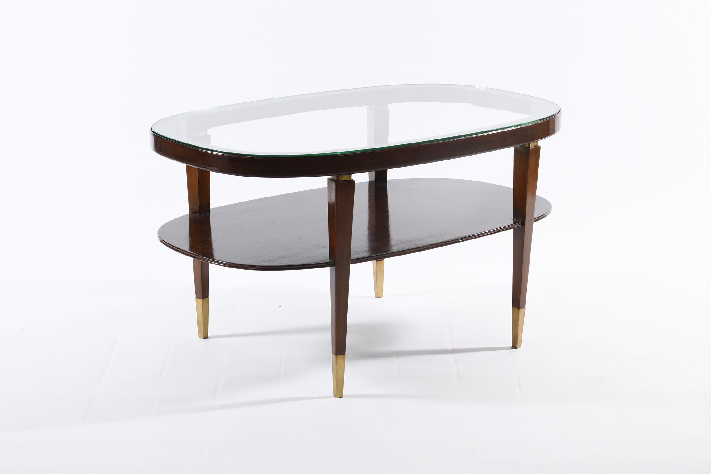 Italian coffee table 1950, oval-shaped solid wood structure with top in beautifully ground glass and embedded in the wooden structure, lower top in wood for books, magazines and newspapers.
Very beautiful the details in cast brass, thin tips finish